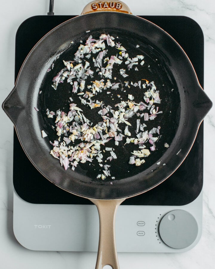 Sautéed shallots and garlic in a skillet.