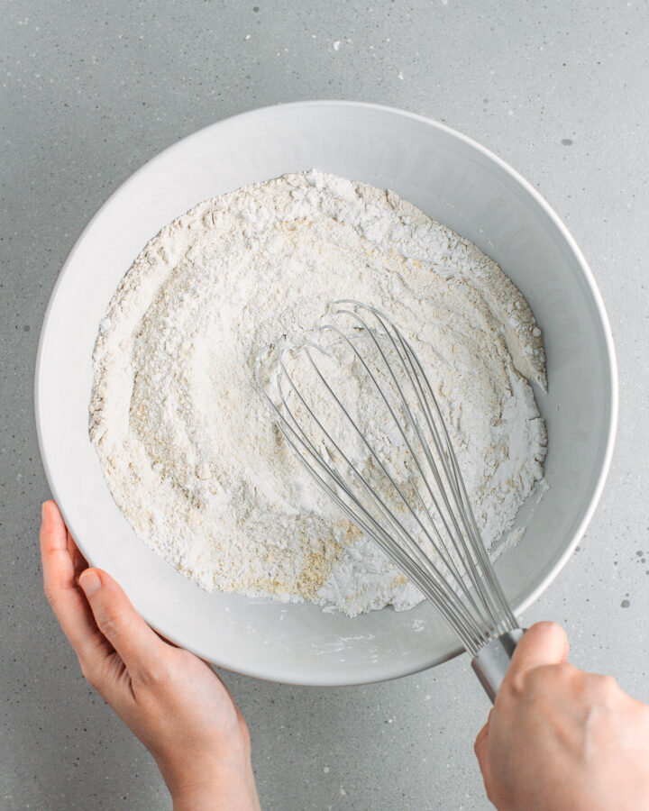 Whisking buckwheat flour with rice flour and tapioca starch in a bowl.