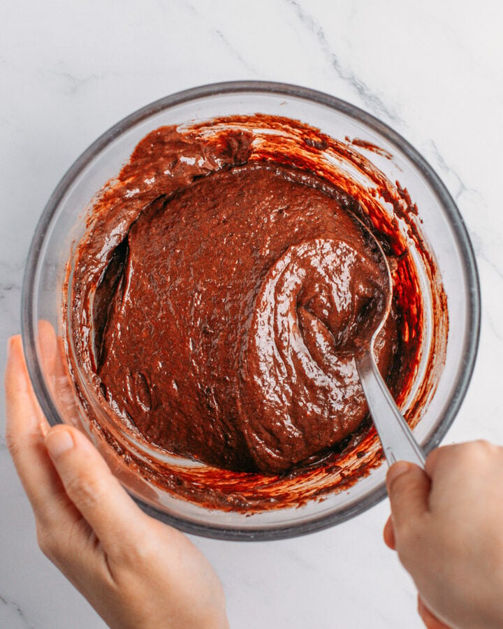 Mixing chocolate cake batter in a small mixing bowl.