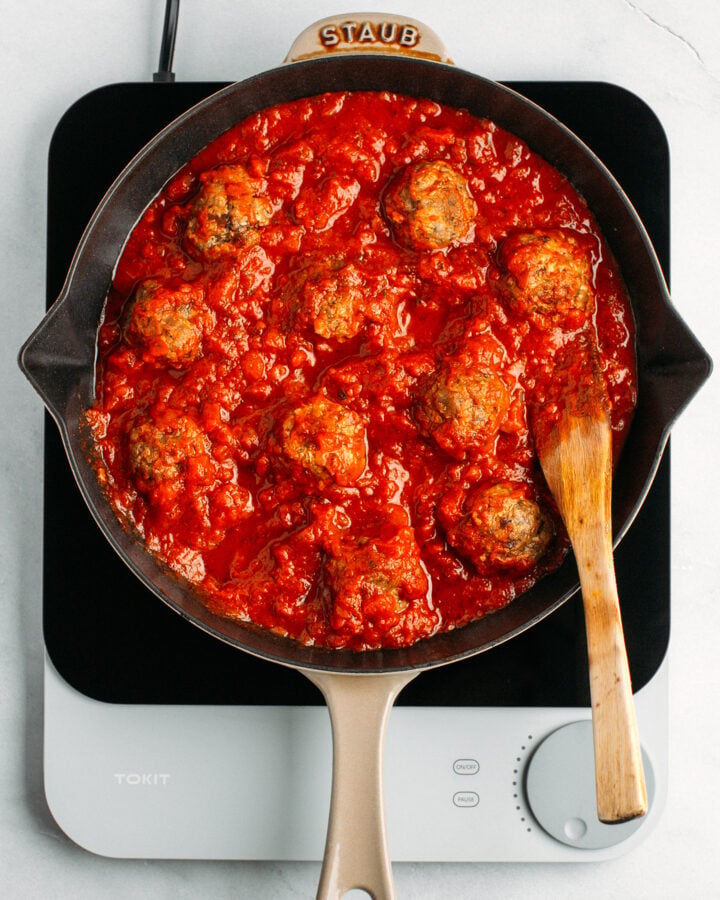 Vegan meatballs with tomato sauce in a skillet.
