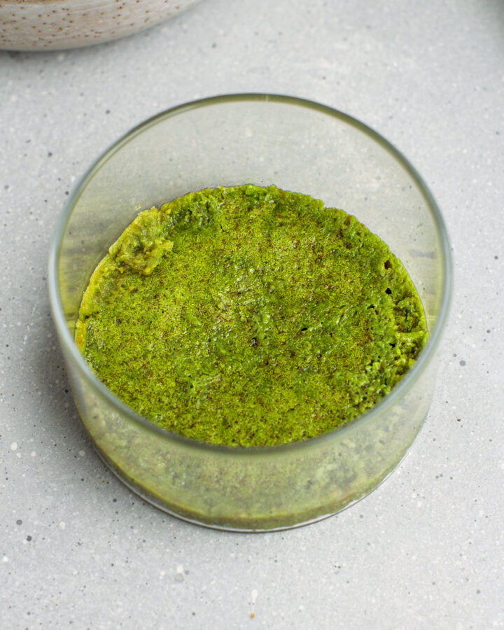 Matcha sponge cake in the bottom of a ramekin.
