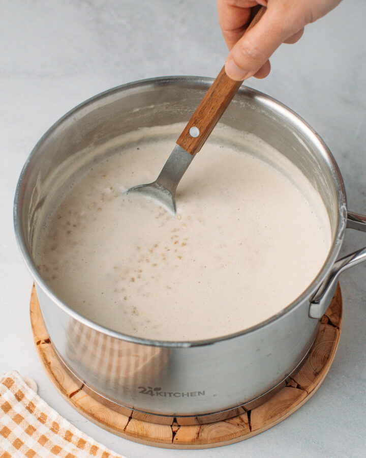 Stirring quinoa pudding in a saucepan.