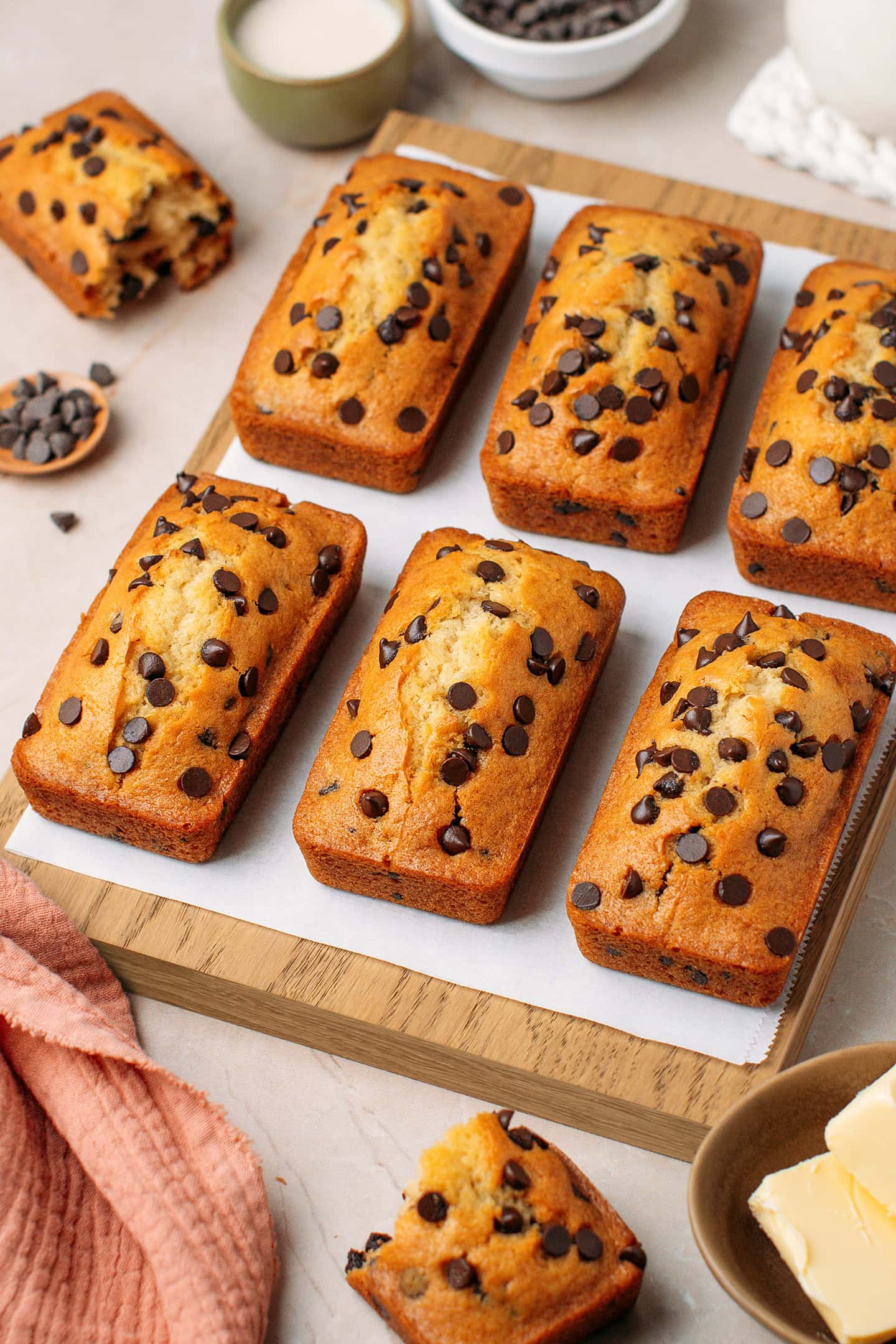 Six mini chocolate chip loaf cakes on a cutting board.