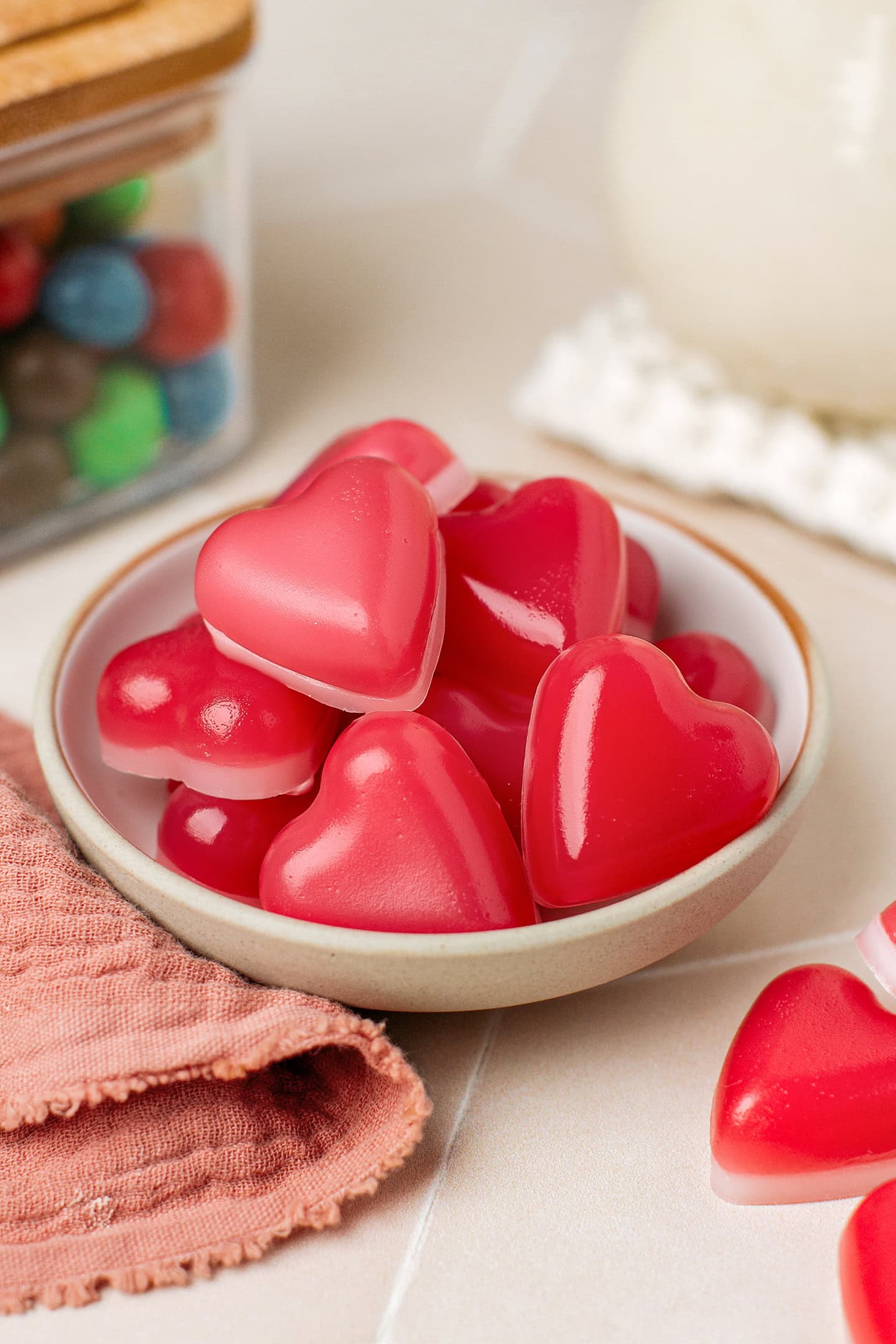 Red heart-shaped gummies in a small grey plate.