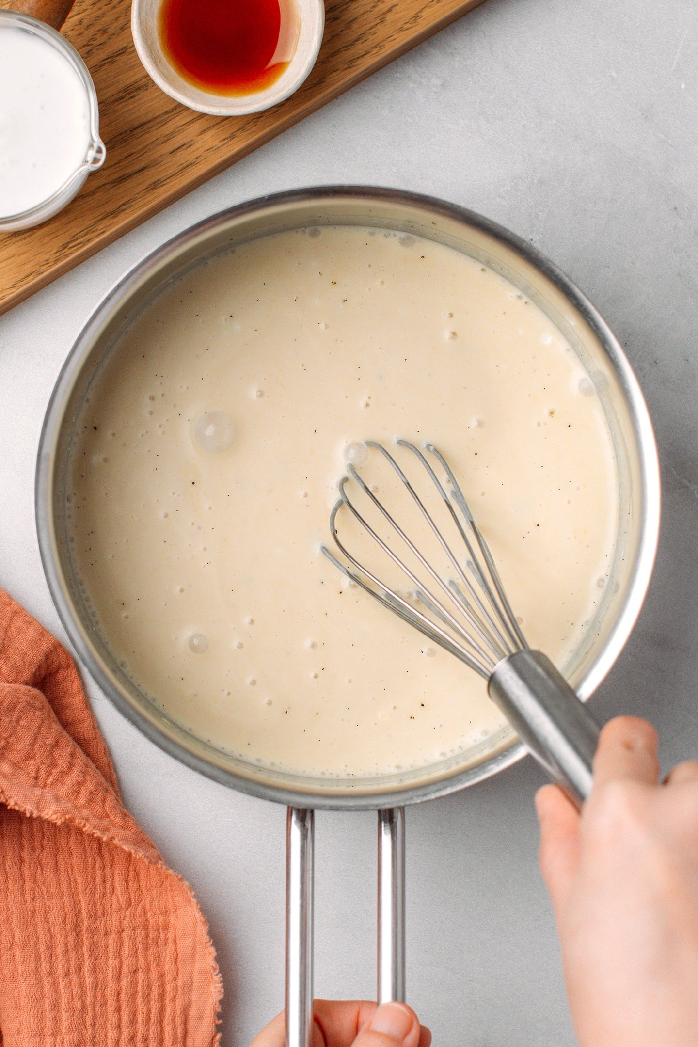 Whisking milk with cornstarch and potato starch in a saucepan.