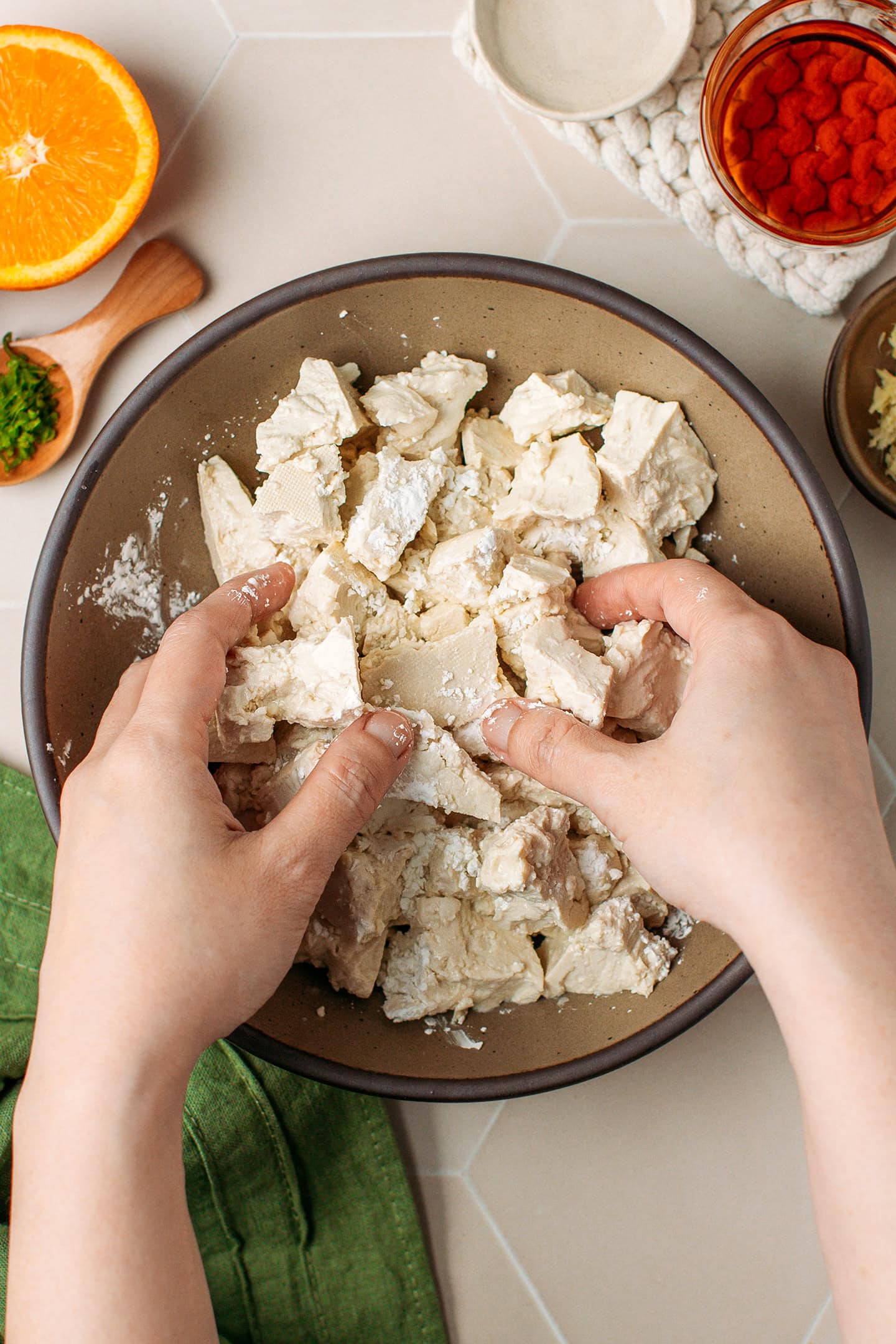 Tossing crumbled tofu with cornstarch in a bowl.