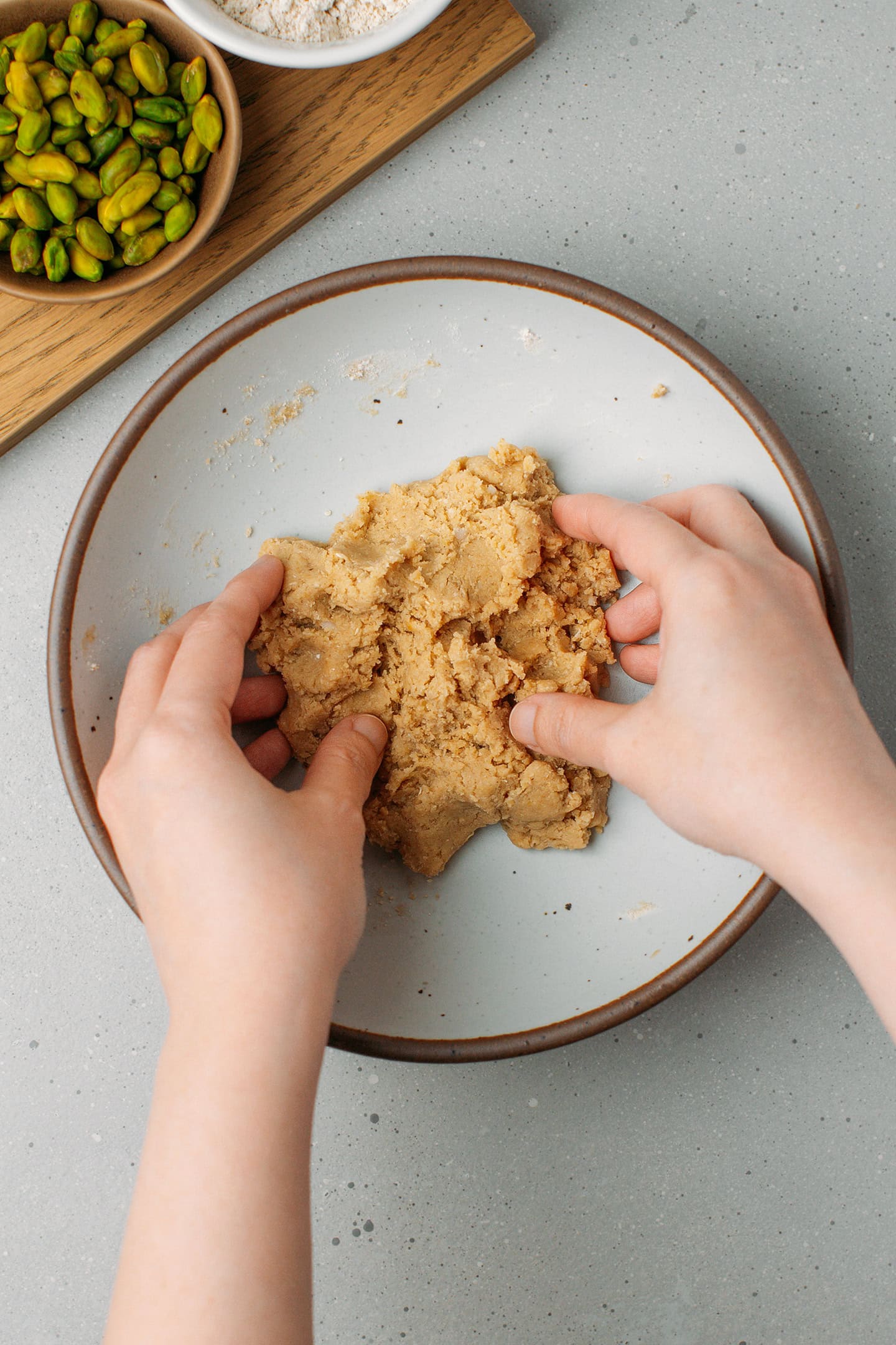 Mixing a shortbread dough using hands.