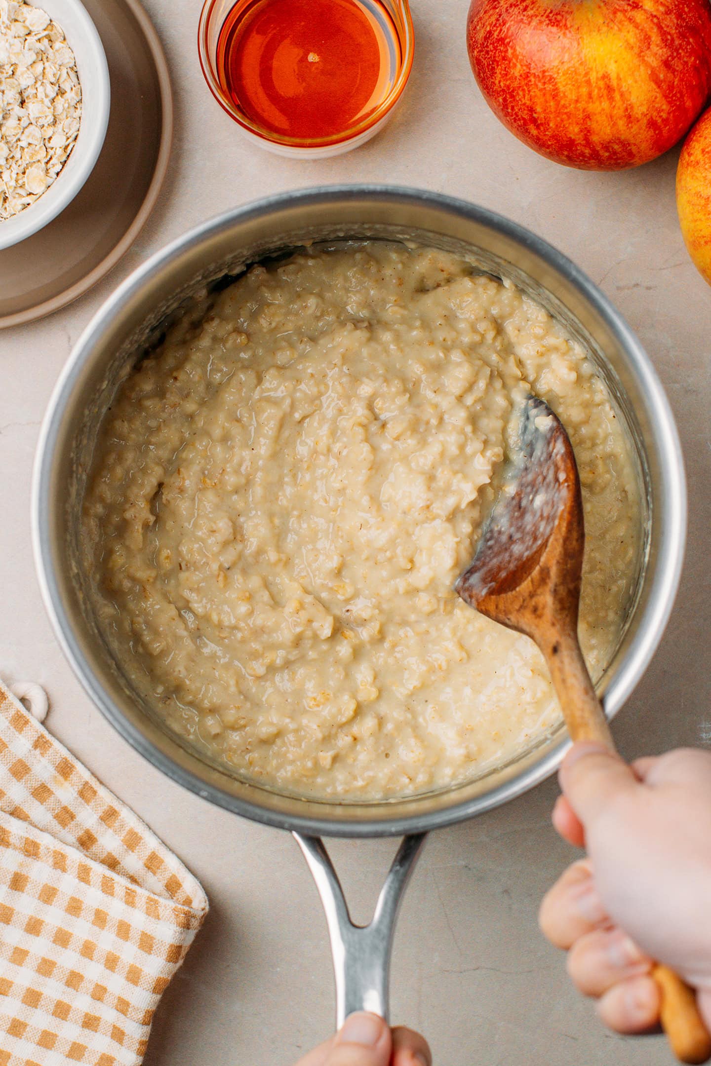 Stirring cooked oatmeal in a saucepan.