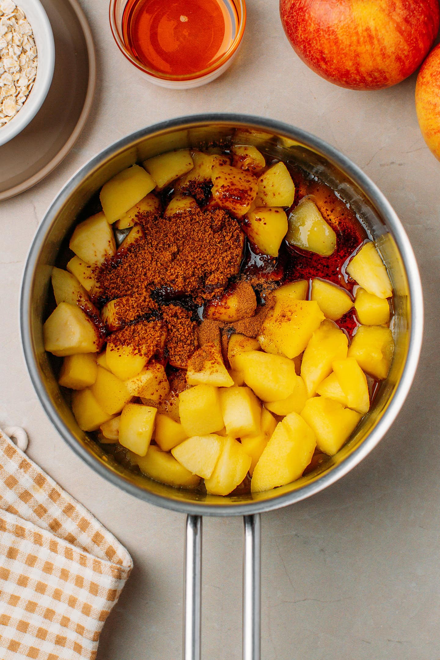 Sautéed diced apples, coconut sugar, and maple syrup in a saucepan.