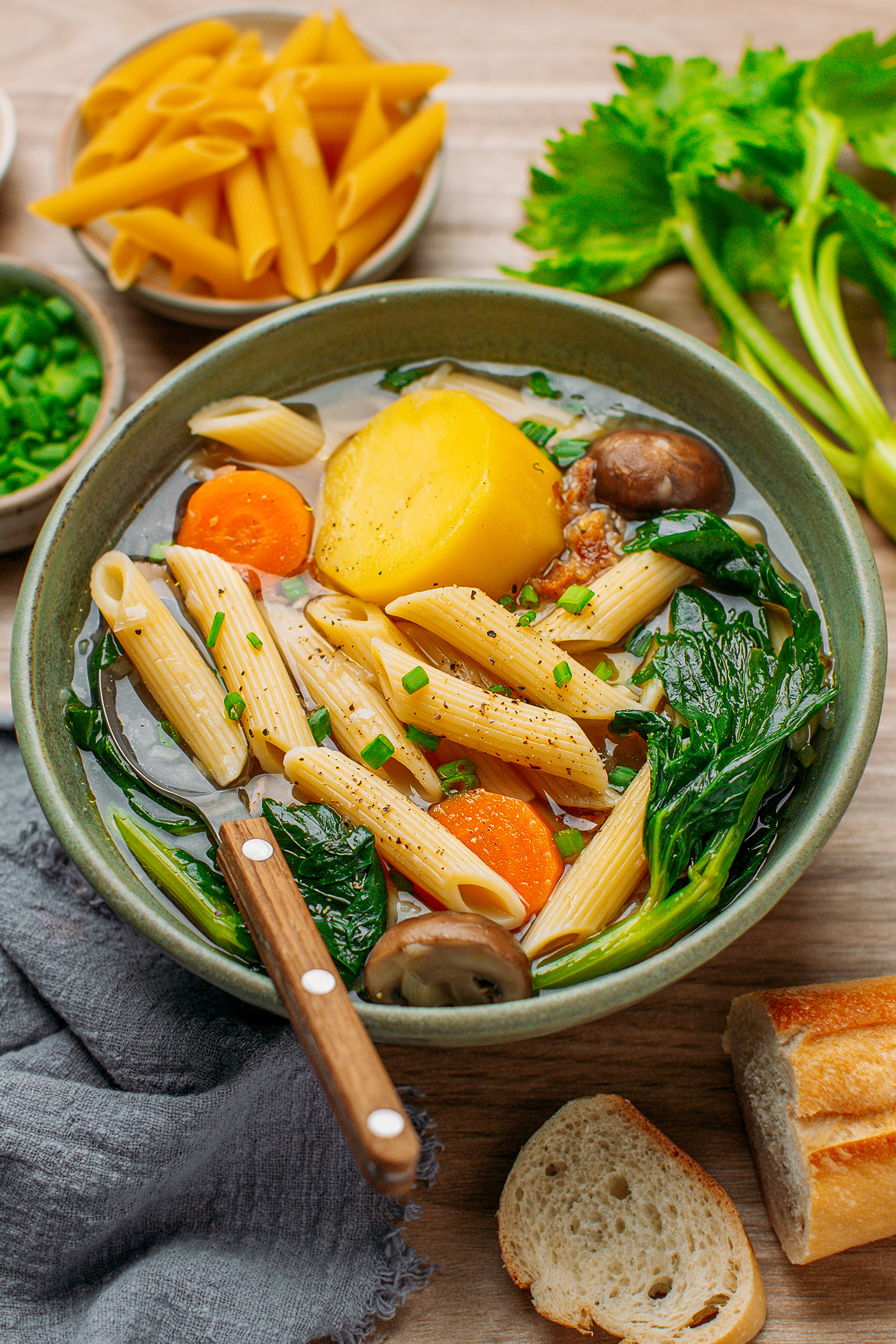 Bowl of vegetable soup with pasta, carrots, and celery.
