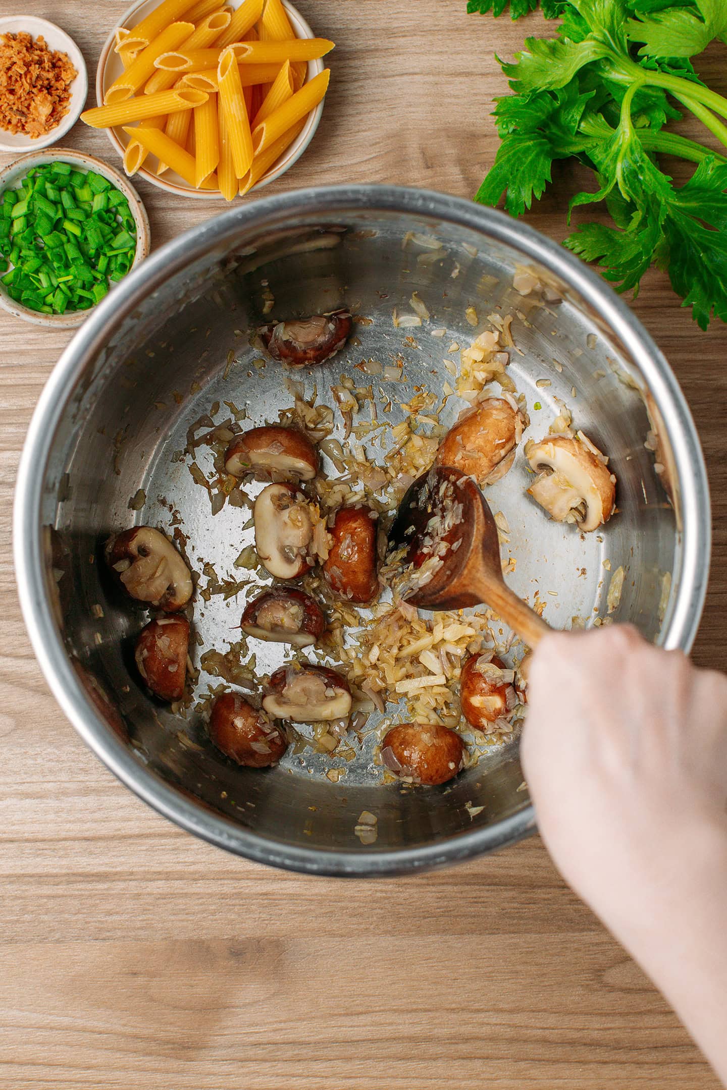 Sautéeing sliced mushrooms in a pot.