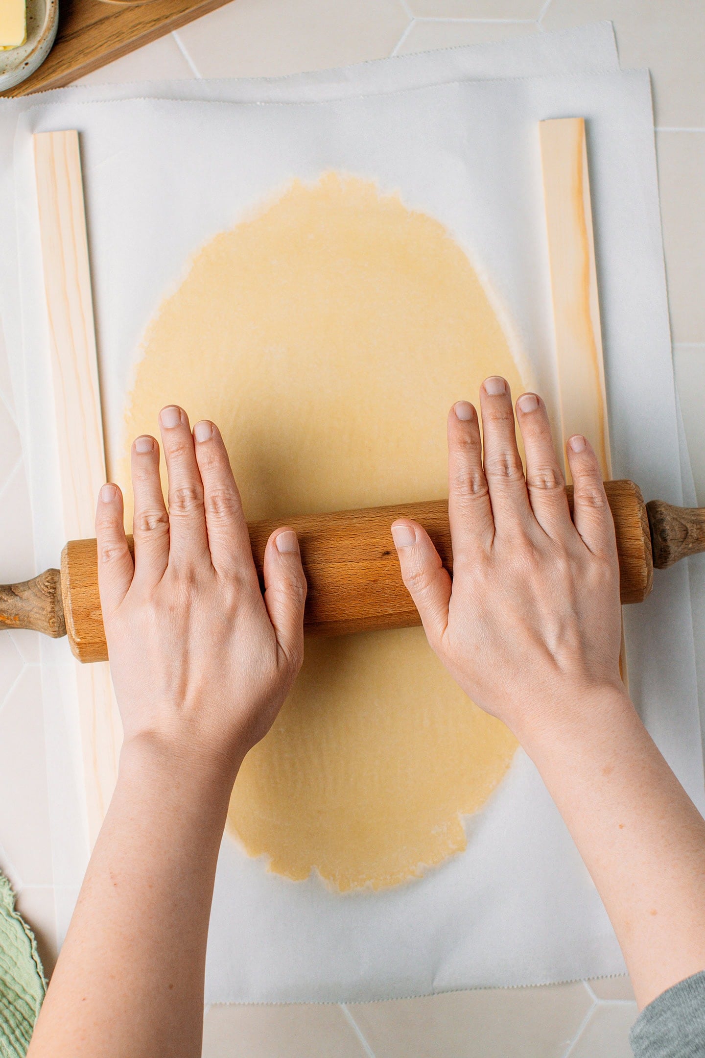 Using a rolling pin to flatten vanilla cookie dough.