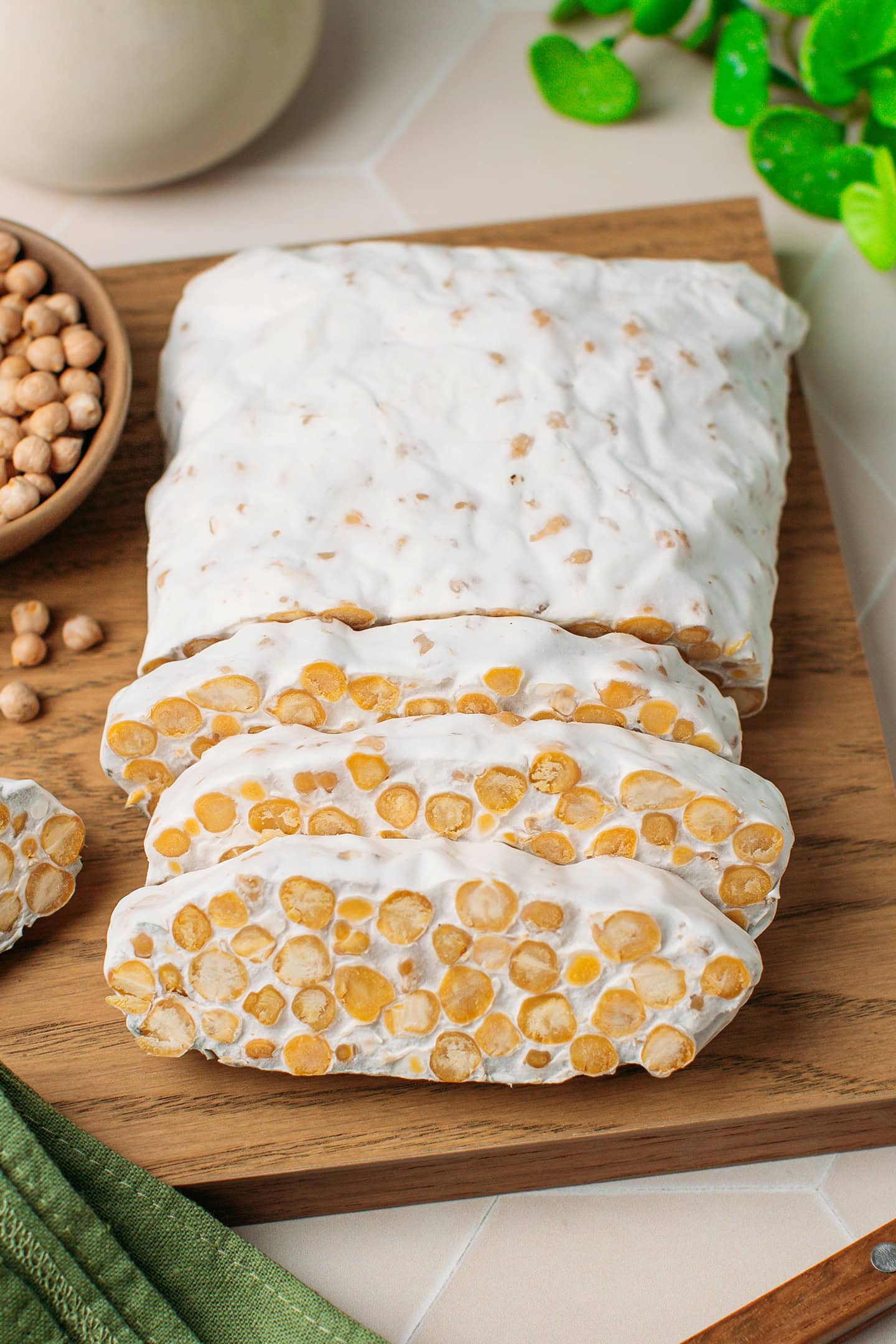 Sliced loaf of chickpea tempeh on a cutting board.