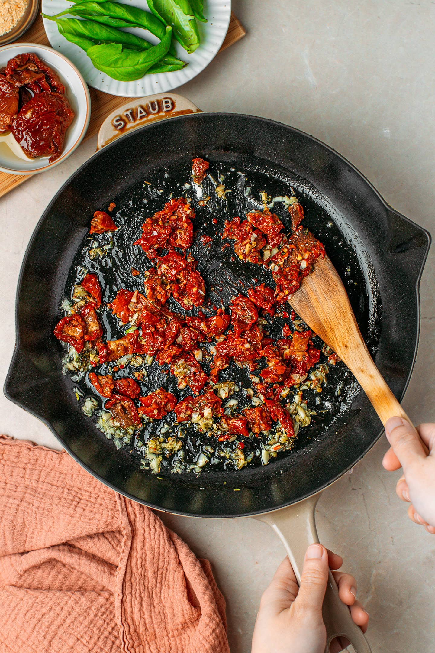 Sautéed garlic and chopped sun-dried tomatoes in a skillet.