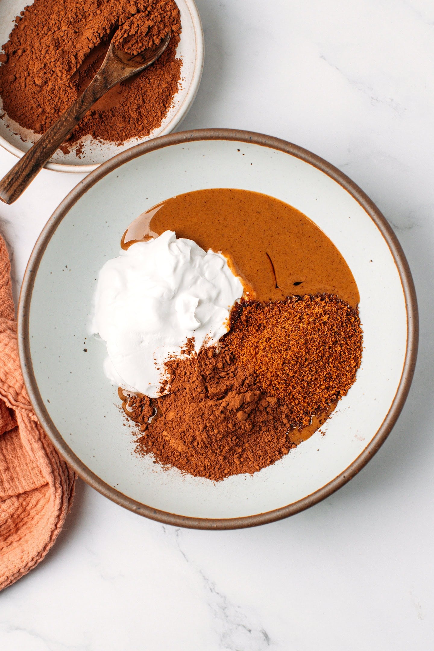 Coconut cream, cocoa powder, coconut sugar, and hazelnut butter in a mixing bowl.