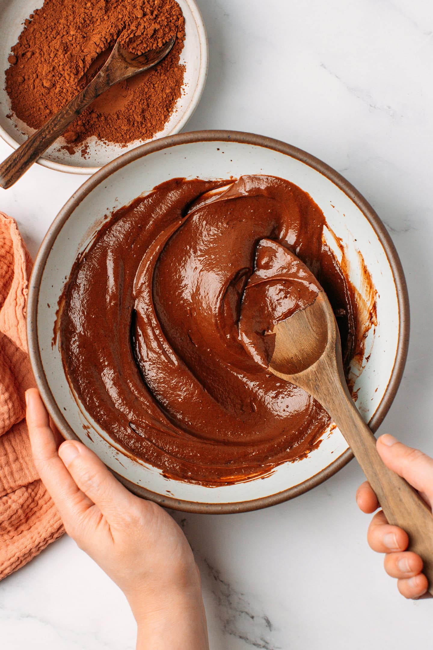 Mixing coconut cream, cocoa powder, and coconut sugar in a mixing bowl.
