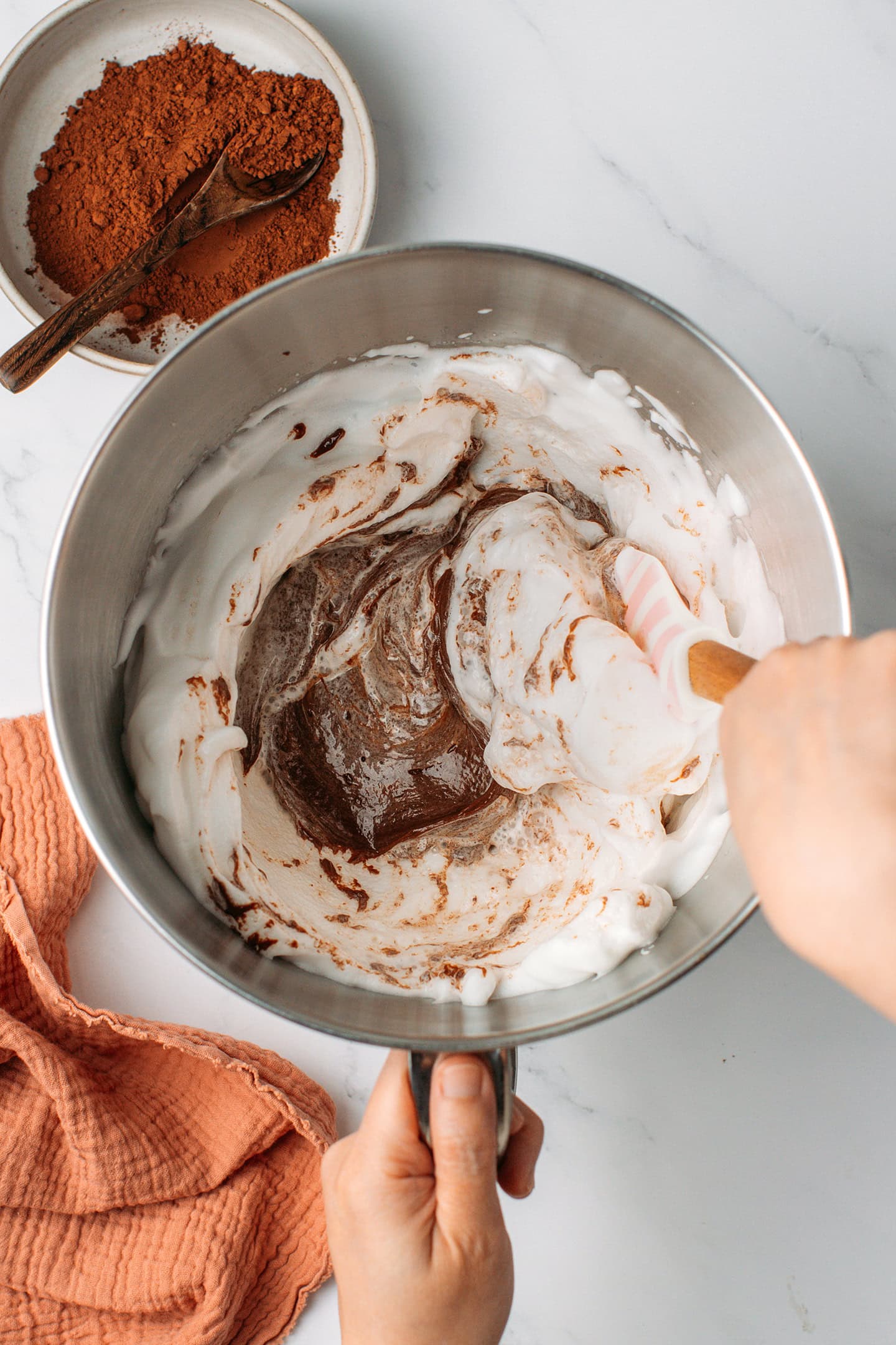 Folding chocolate mixture into whipped aquafaba.