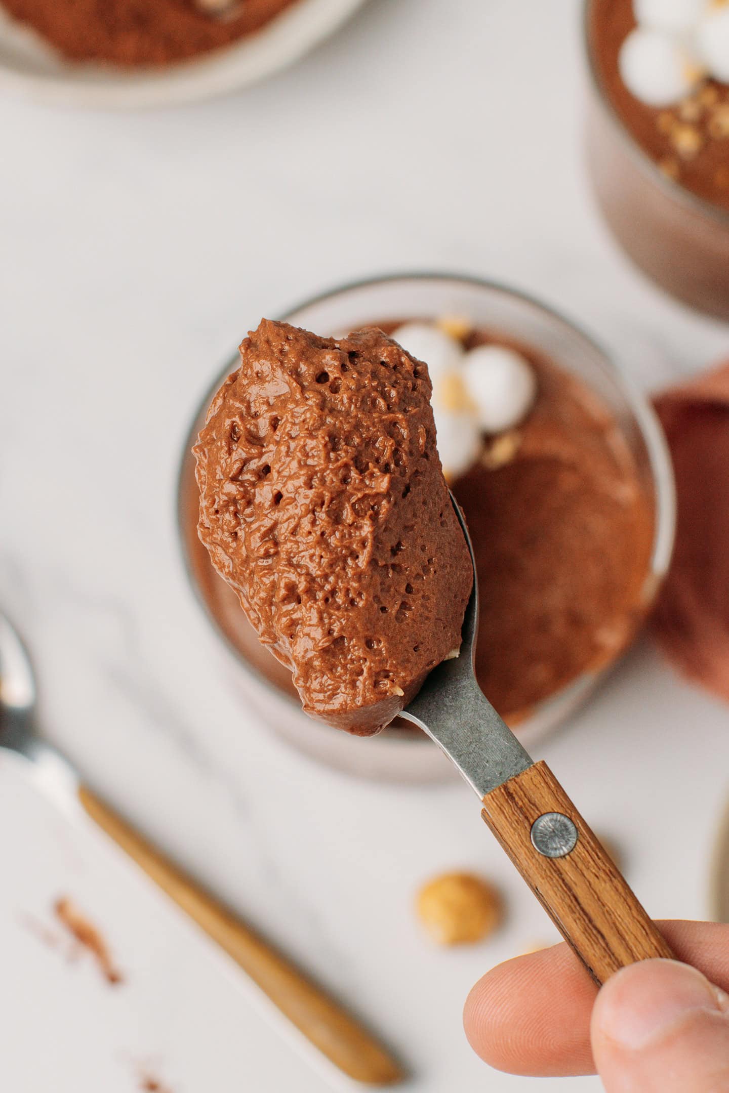 Close-up of a spoonful of vegan chocolate hazelnut mousse, revealing its light texture.