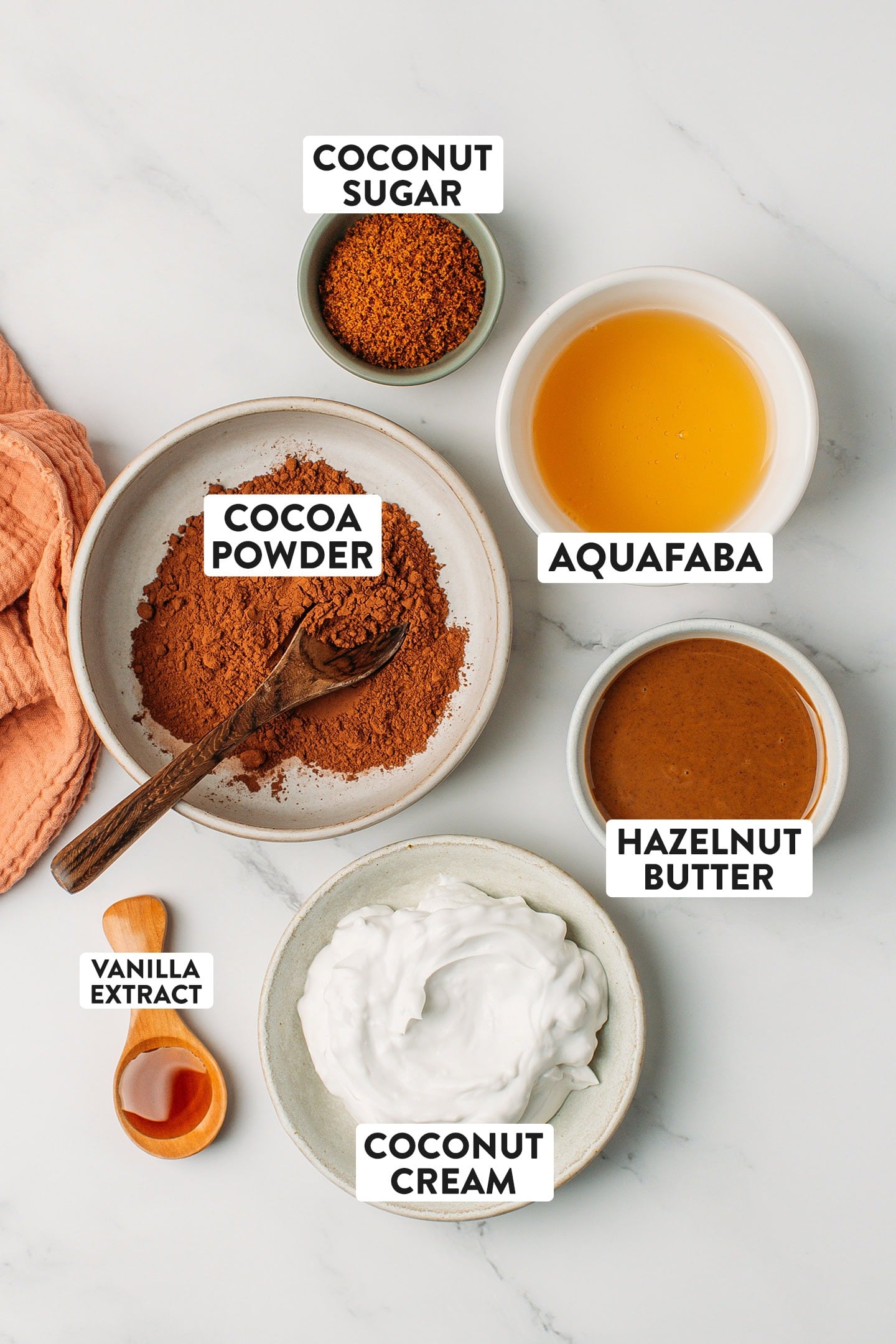 Ingredients like cocoa powder, aquafaba, coconut sugar, and hazelnut butter.