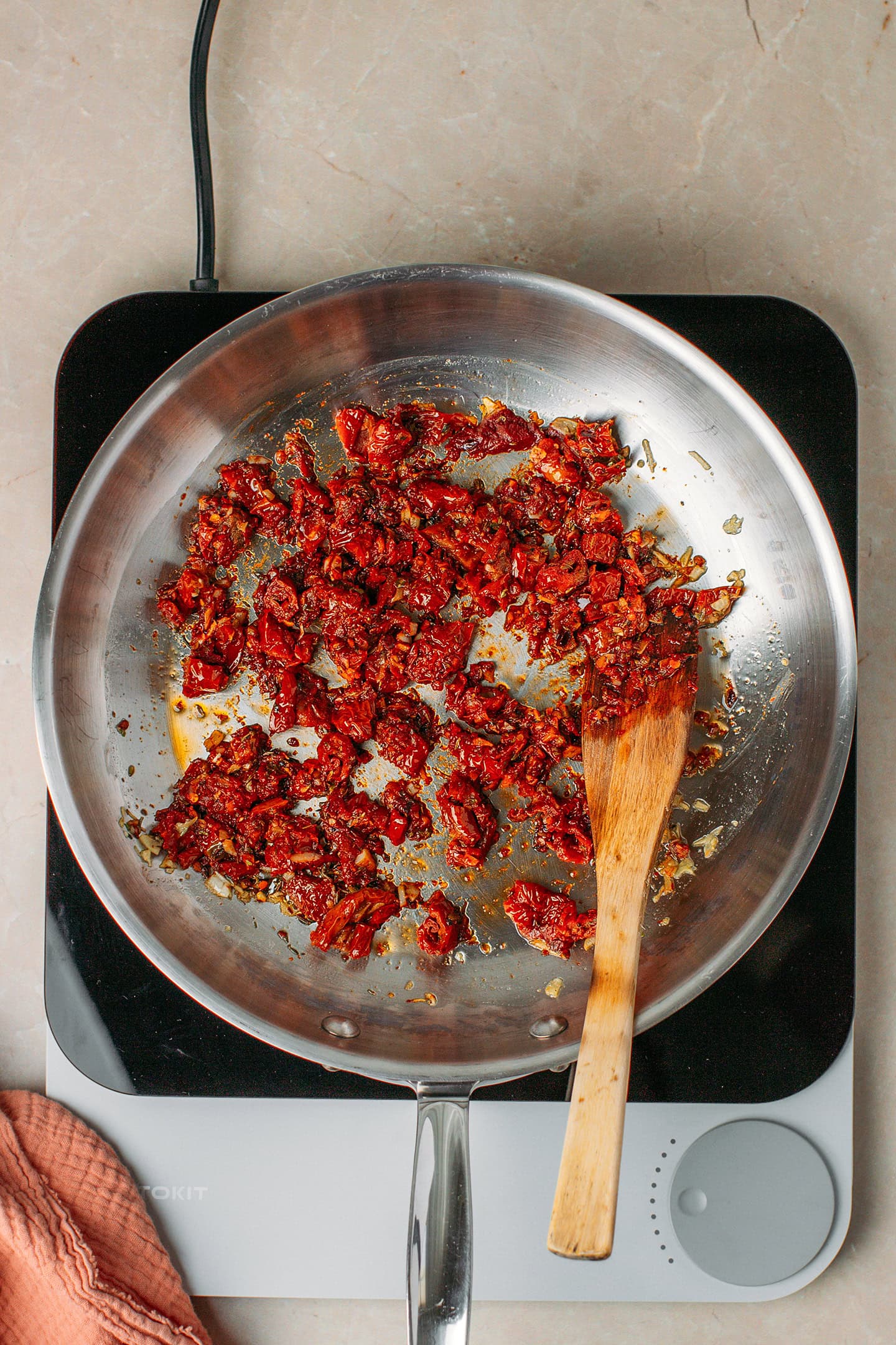 Sautéed chopped sun-dried tomatoes in a skillet.