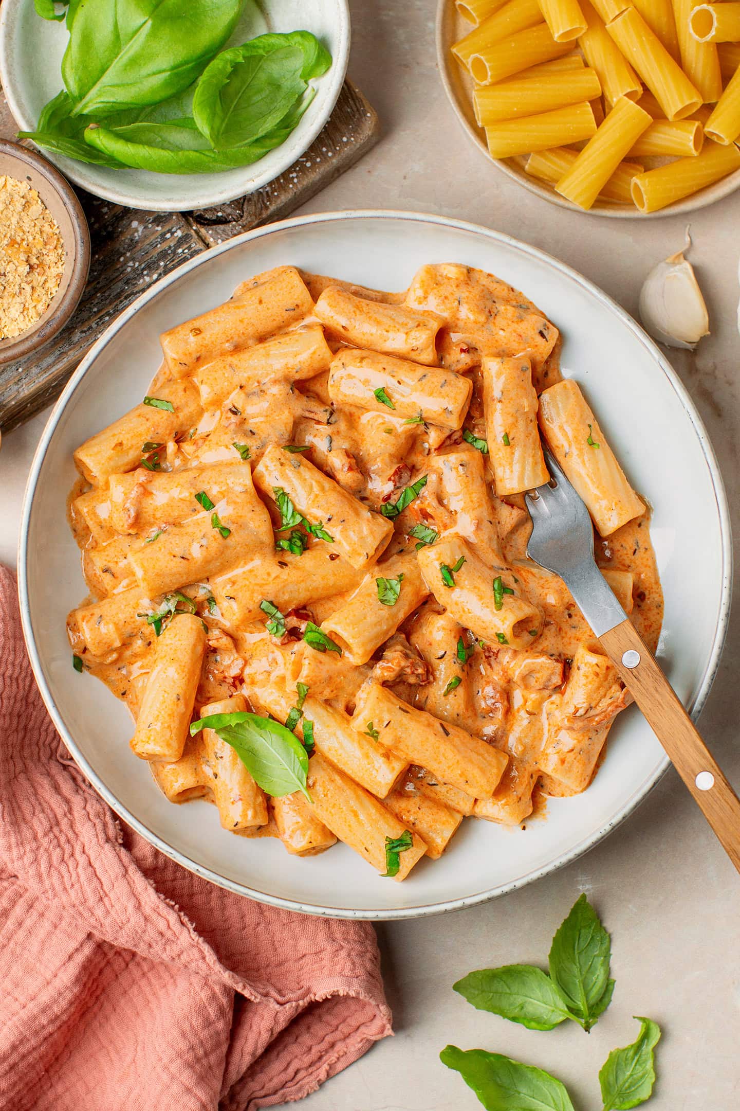 Pasta coated with a creamy sun-dried tomato sauce and topped with chopped basil.