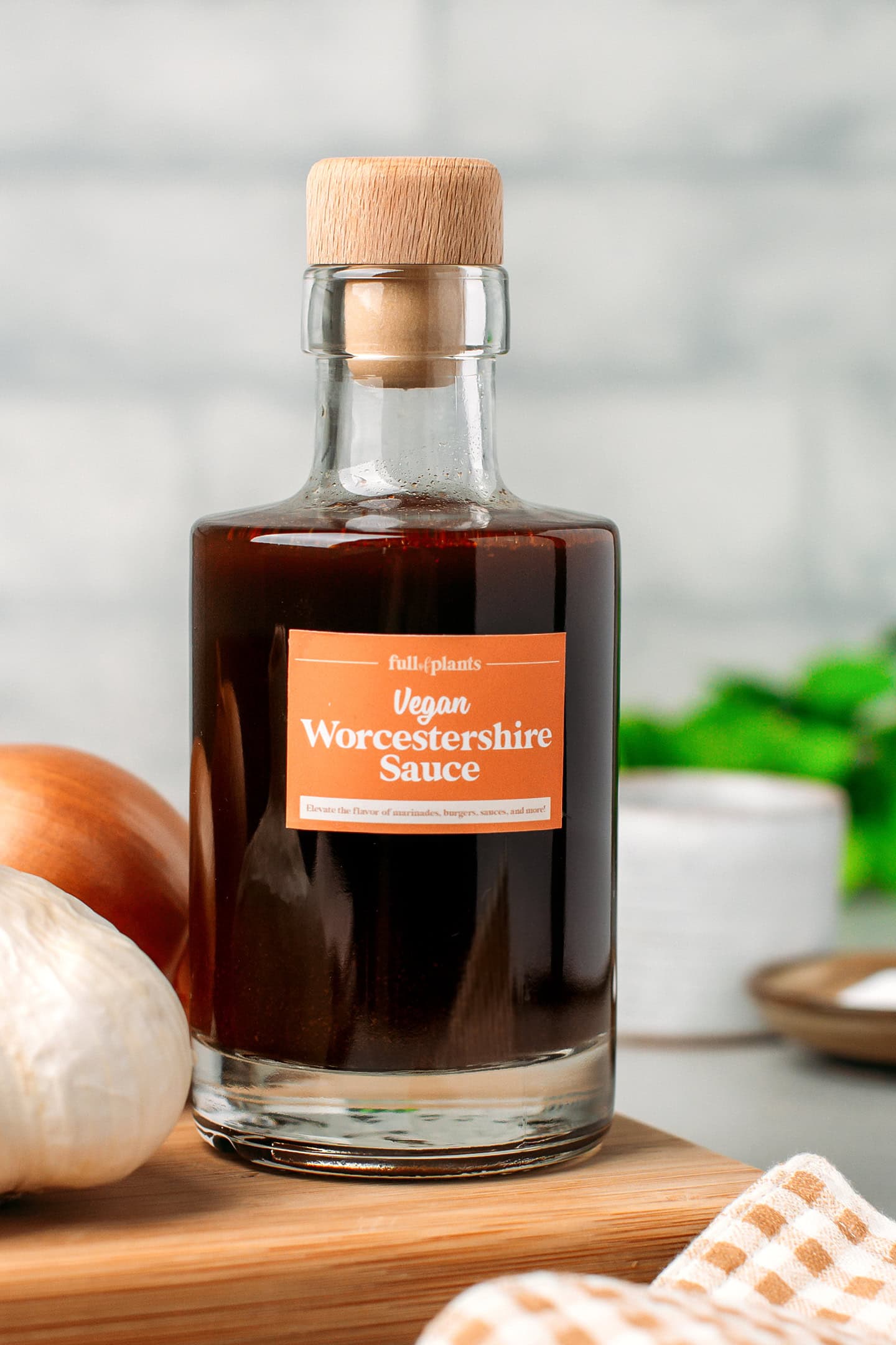 Bottle of homemade vegan Worcestershire sauce on a wooden board.
