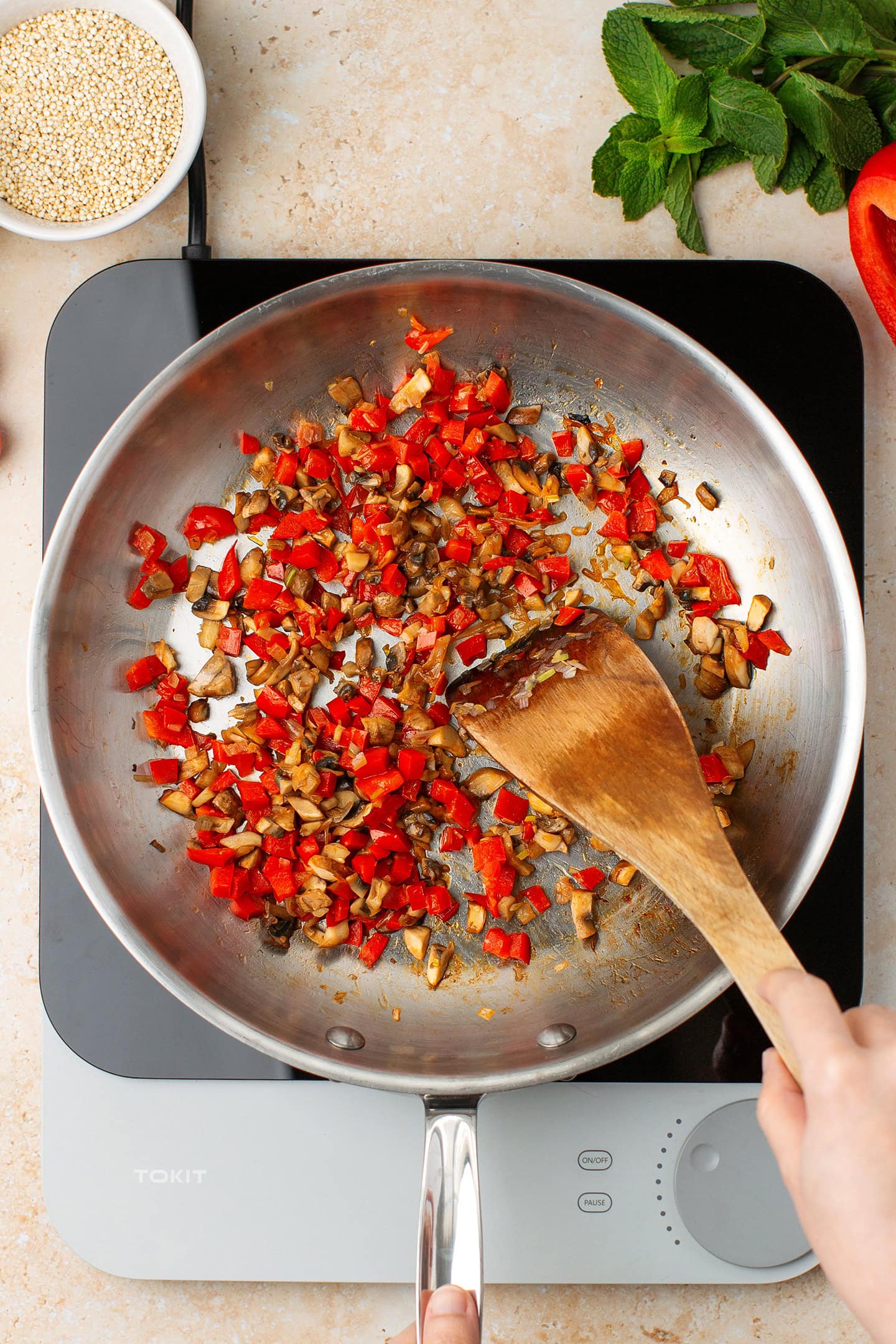 Sautéed diced bell peppers and mushrooms in a skillet.