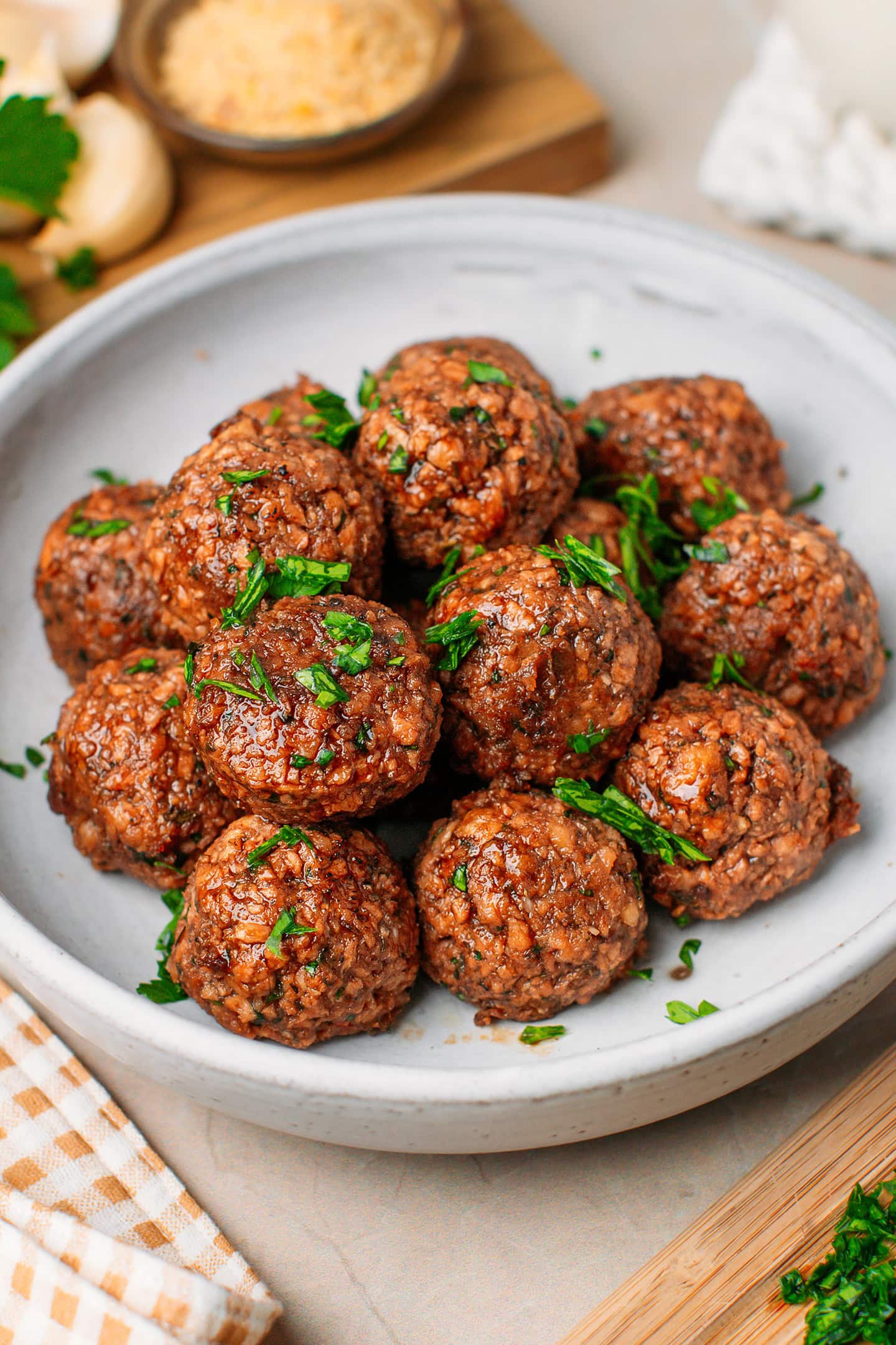 Vegan meatballs made with TVP and garnished with chopped parsley in a deep plate.