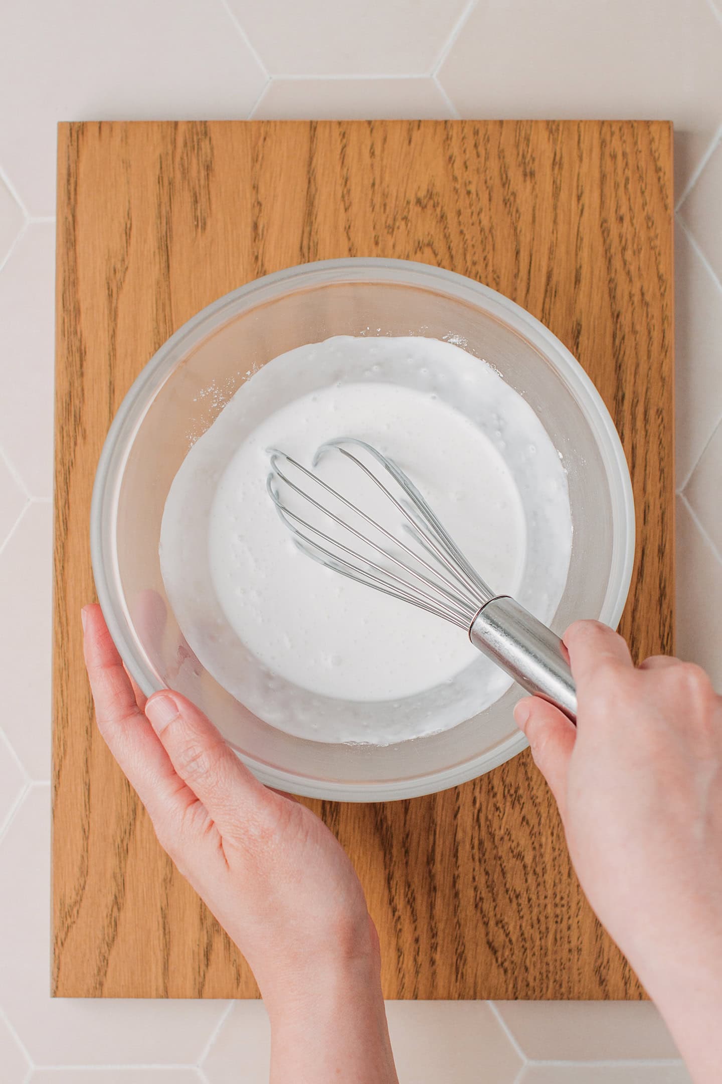 Whisking coconut milk with tapioca starch and rice flour in a bowl.