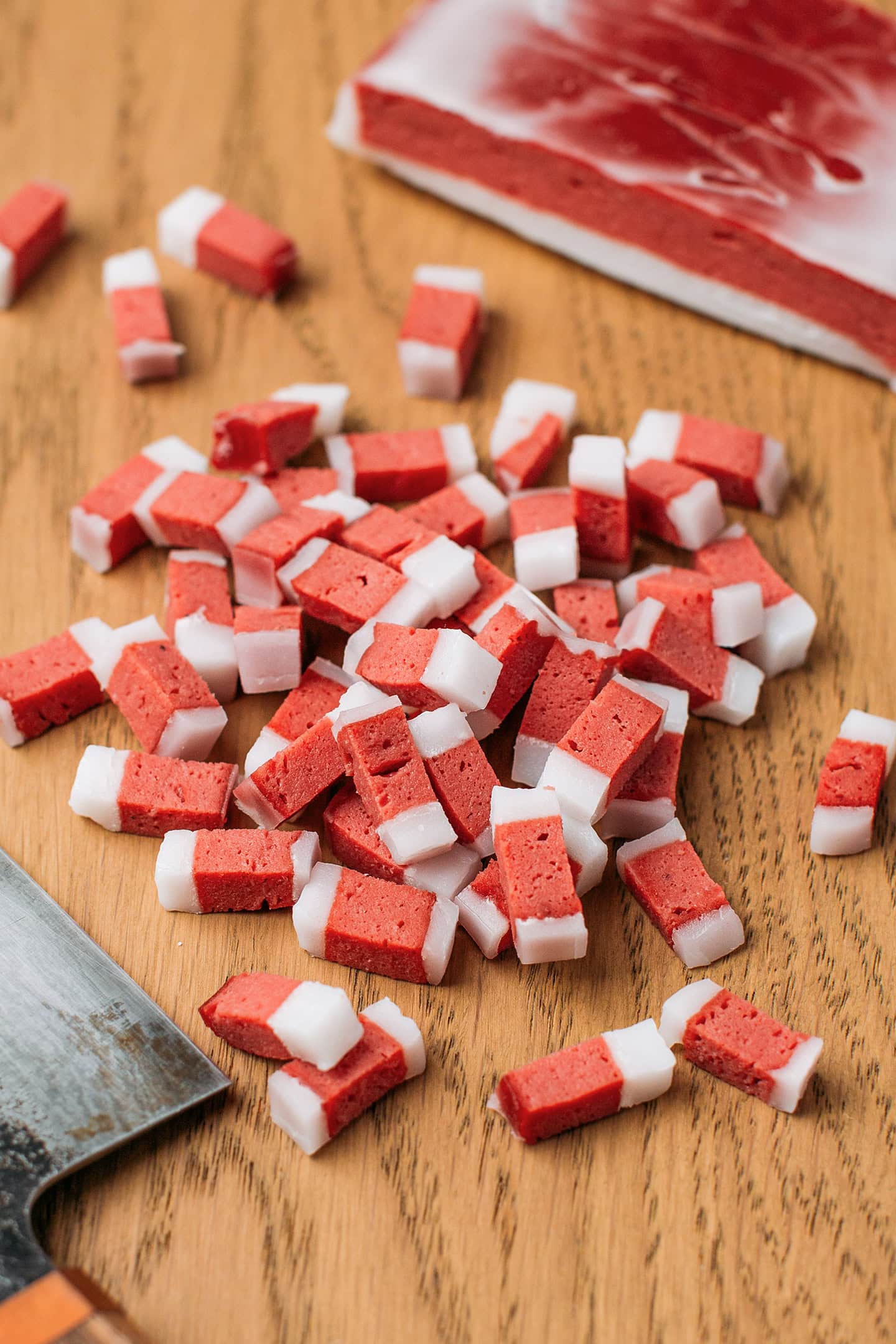 Sliced vegan bacon bits on a wooden cutting board.