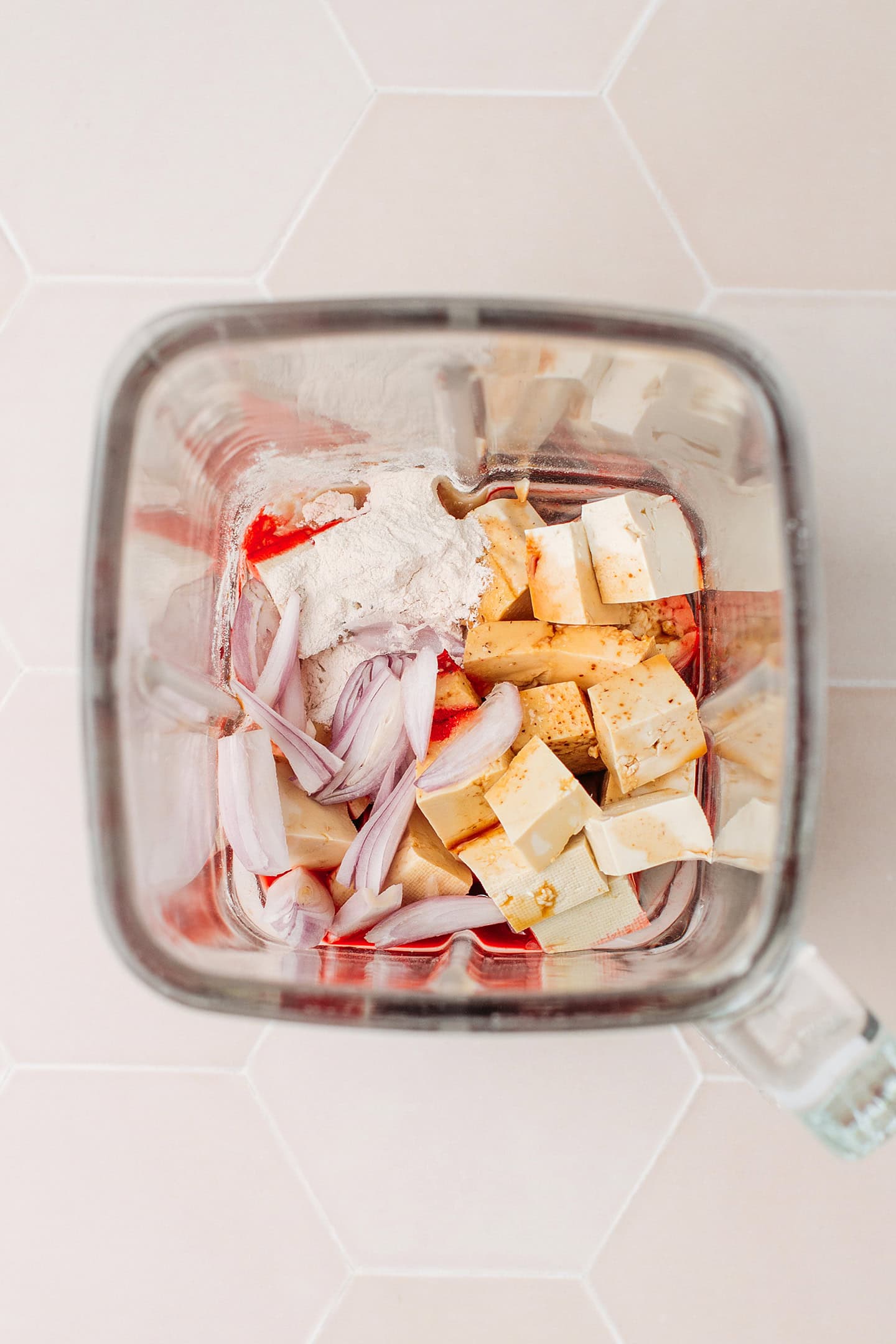 Diced tofu, shallot, onion powder, and red food coloring in a blender.