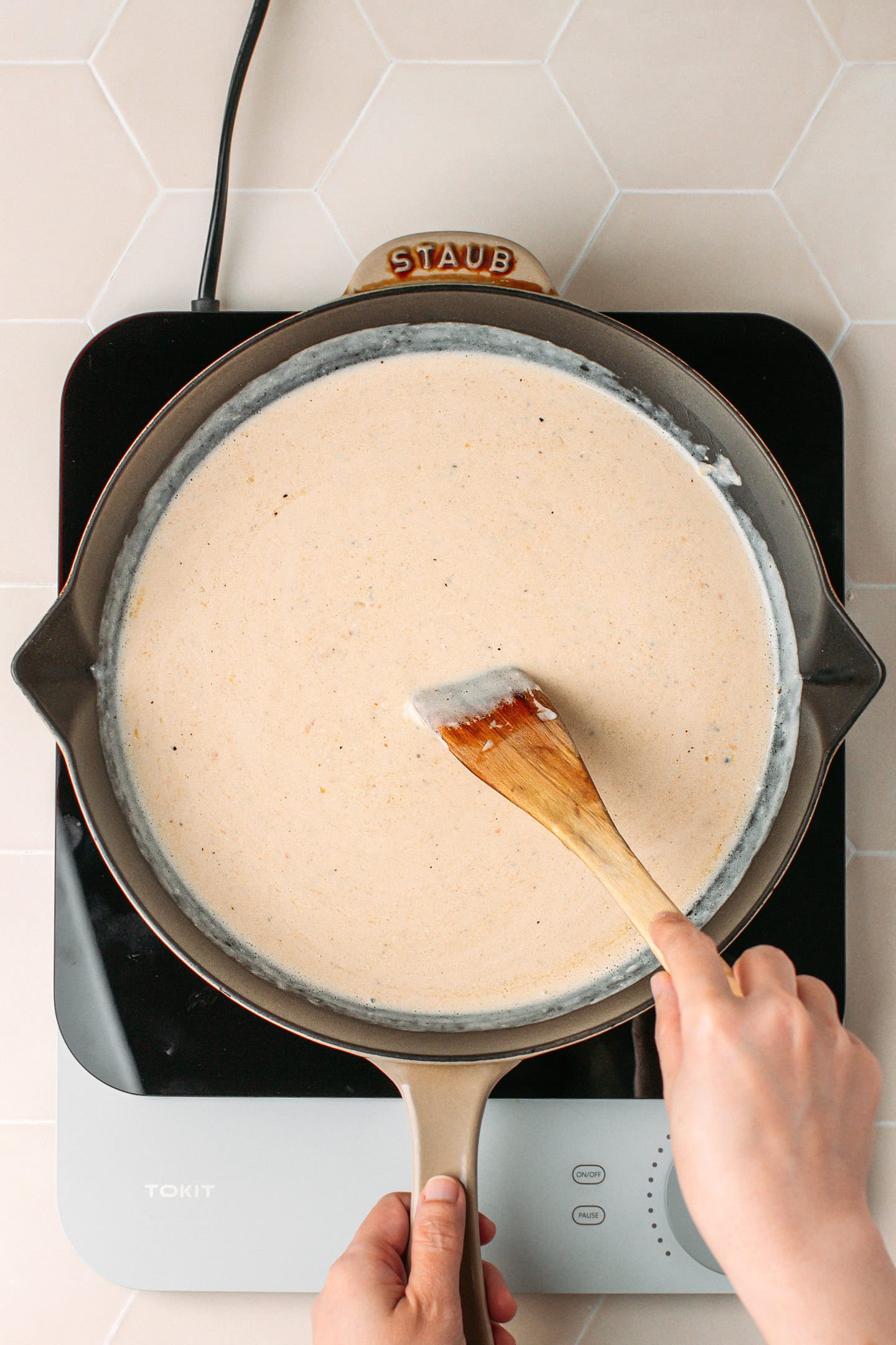 Stirring carbonara sauce in a skillet.