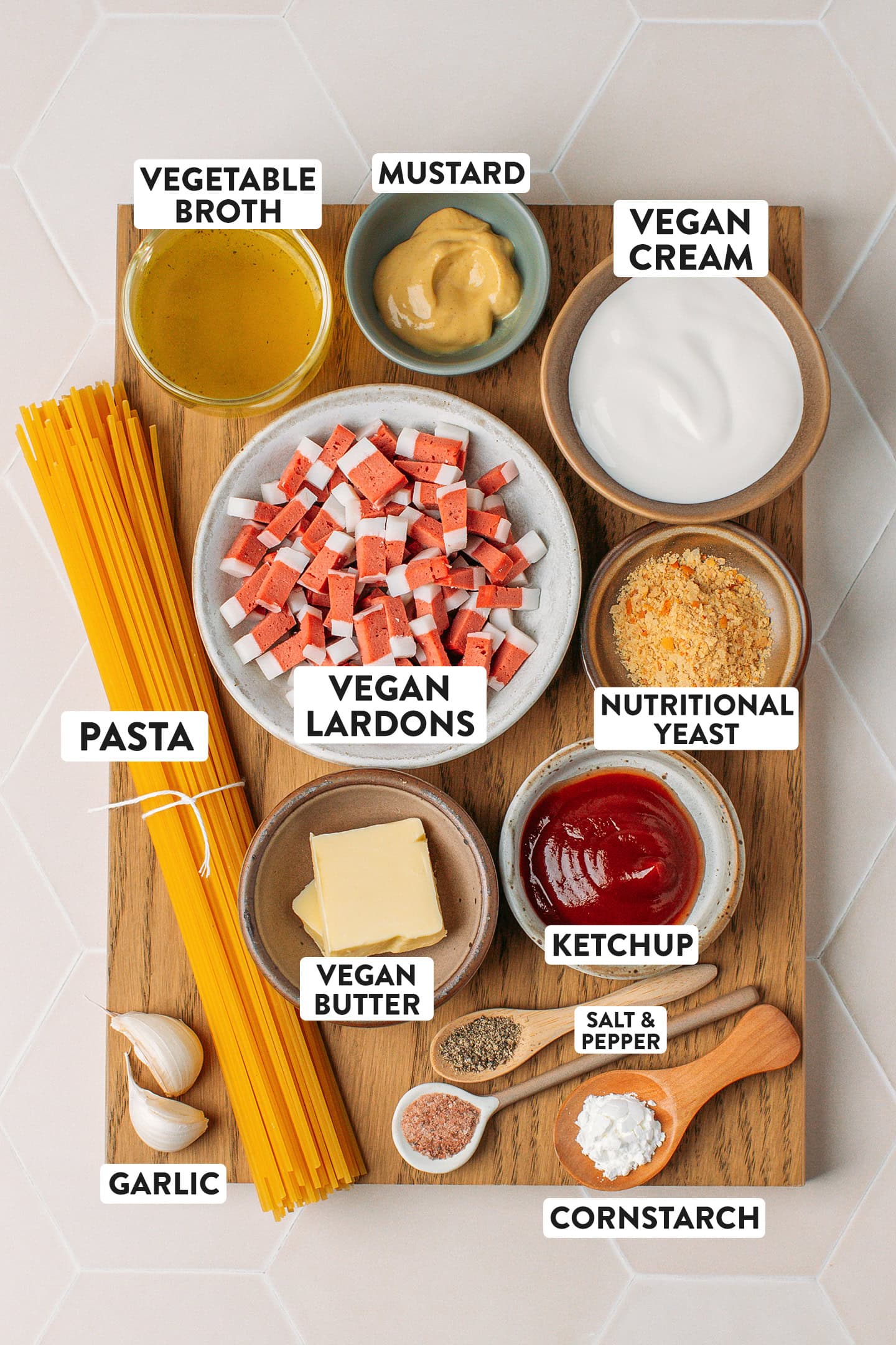 Ingredients like spaghetti, vegan butter, vegan bacon bits, nutritional yeast, and plant-based cream.