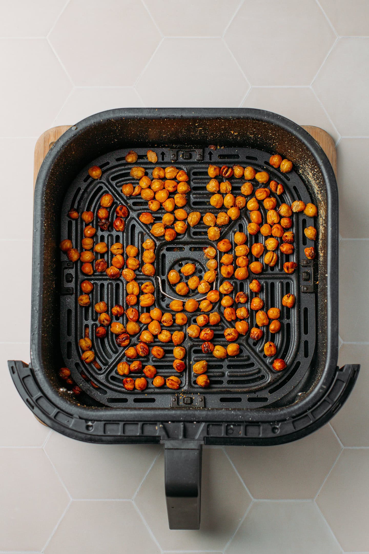 Crispy golden brown chickpeas in an air fryer basket.