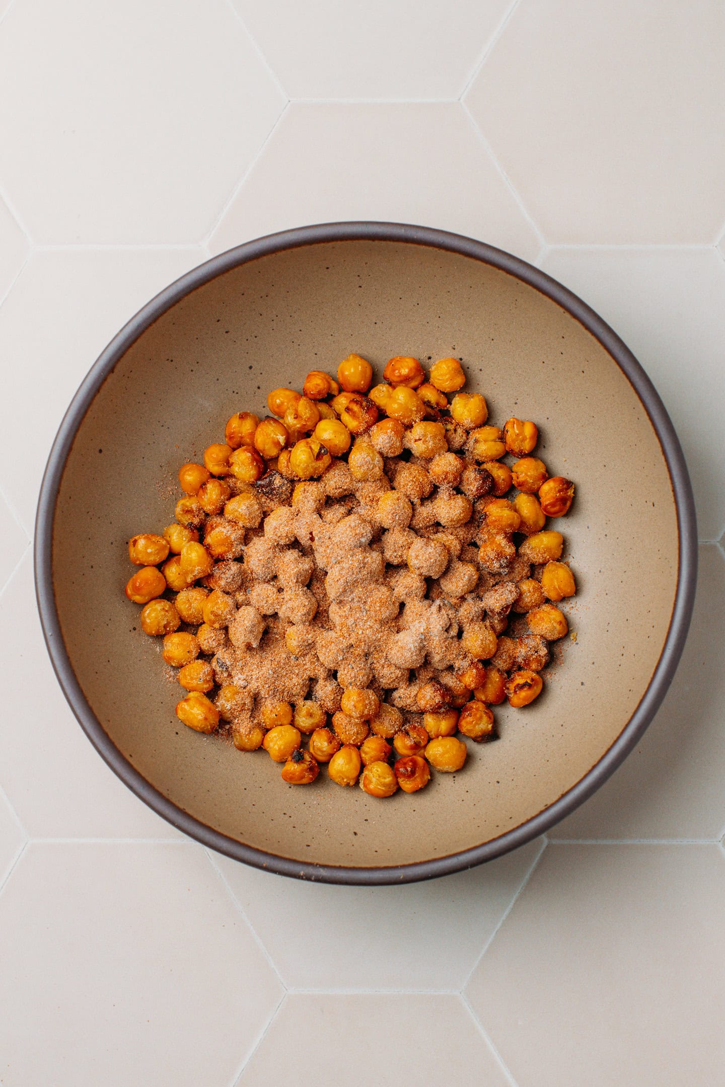 Crispy chickpeas and spices in a mixing bowl.