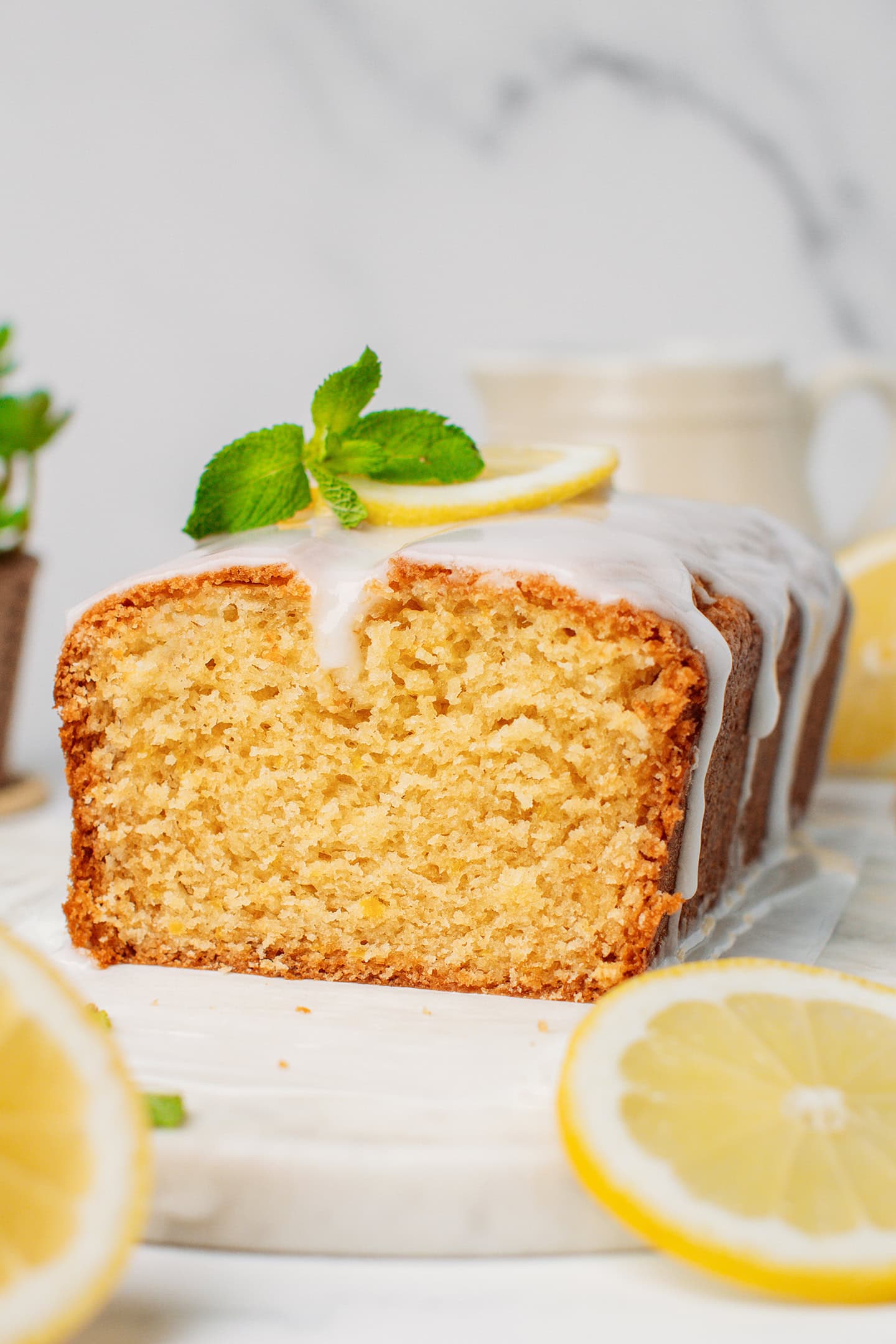 Glazed lemon loaf cake topped with mint leaves.