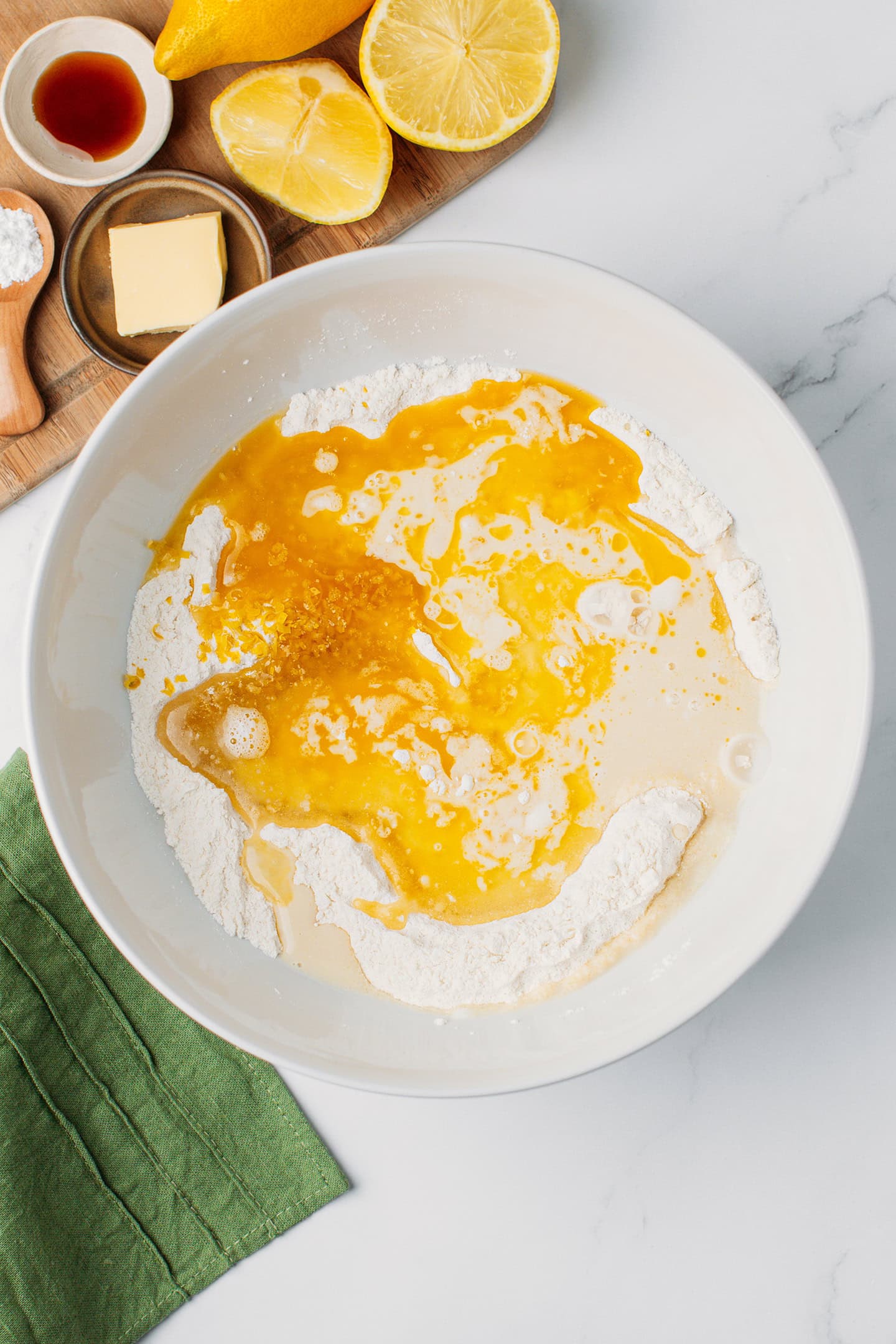 Flour, sugar, lemon zest, melted butter, and milk in a mixing bowl.