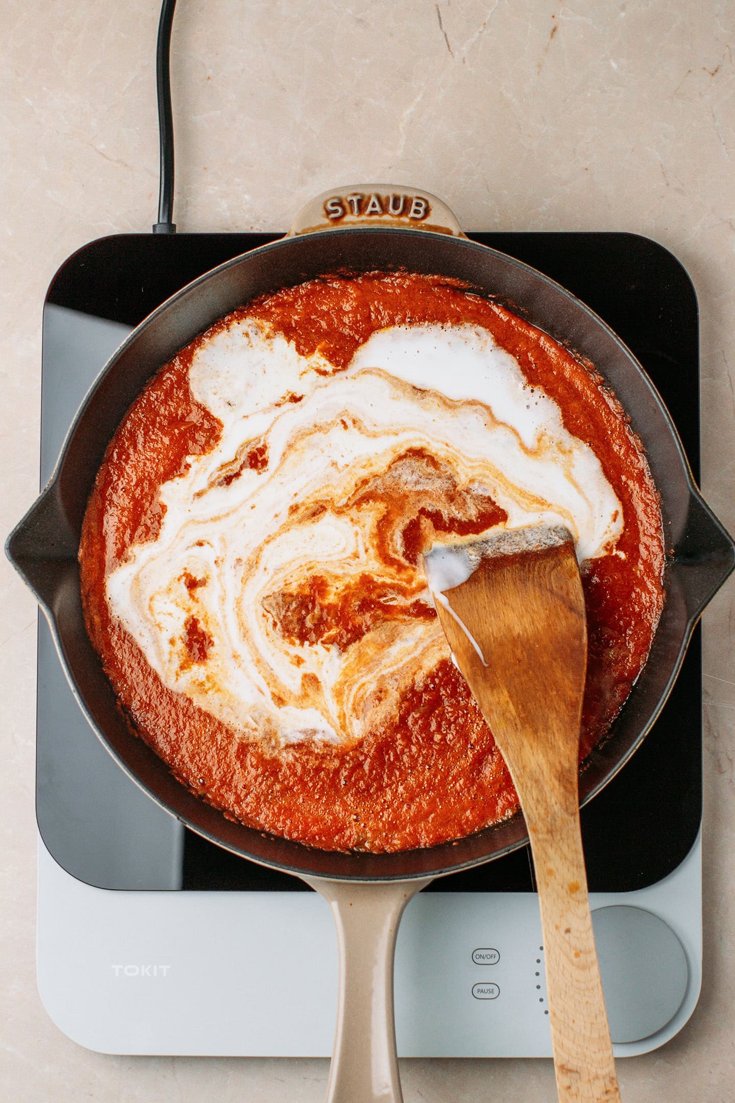 Tomato sauce and coconut milk in a skillet.