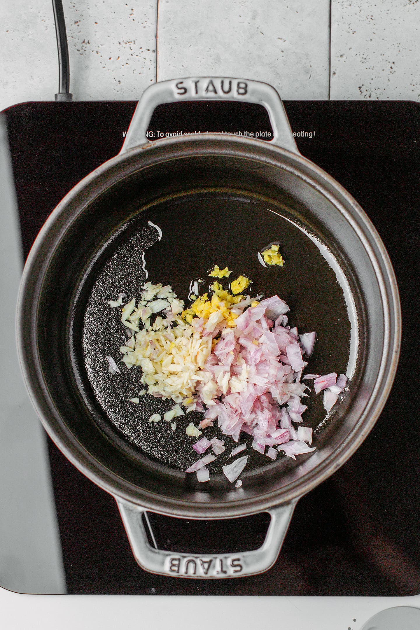 Minced shallot, ginger, and garlic in a pot.