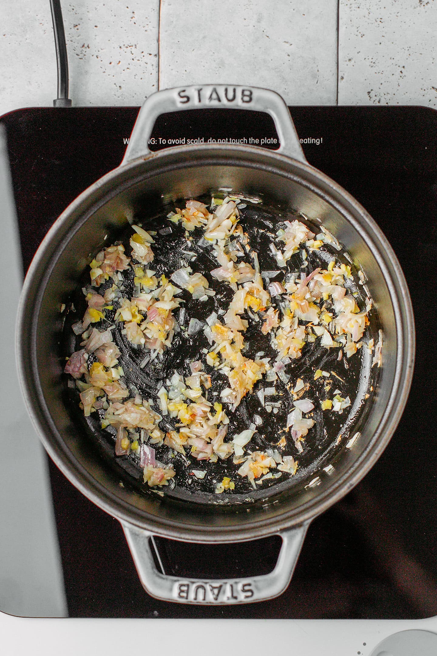 Sautéed ginger, garlic, and shallot in a pot.