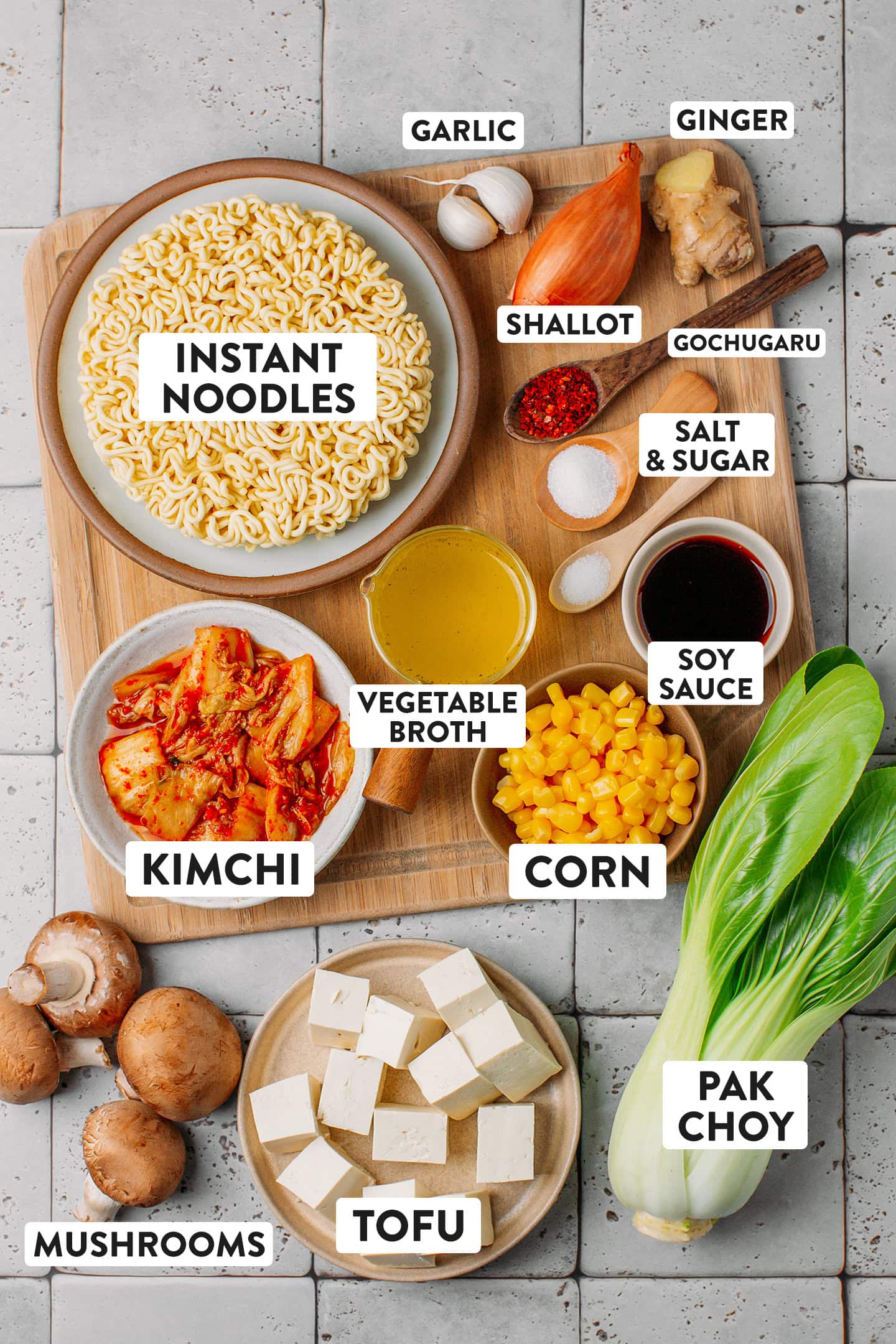 Ingredients like instant noodles, kimchi, vegetable broth, soy sauce, and tofu.