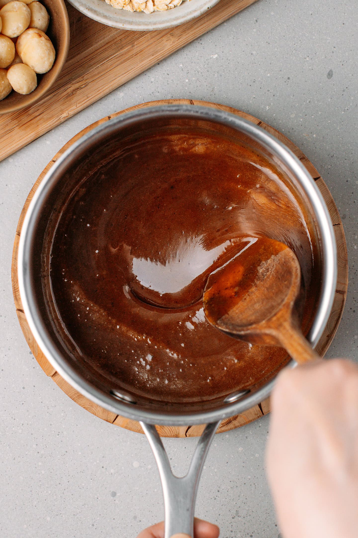 Mixing brown rice syrup with peanut butter and coconut sugar in a saucepan.