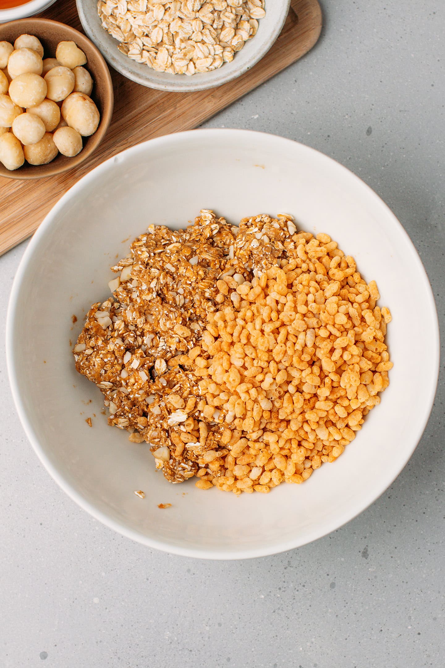 Sticky oat mixture and rice crisps in a mixing bowl.