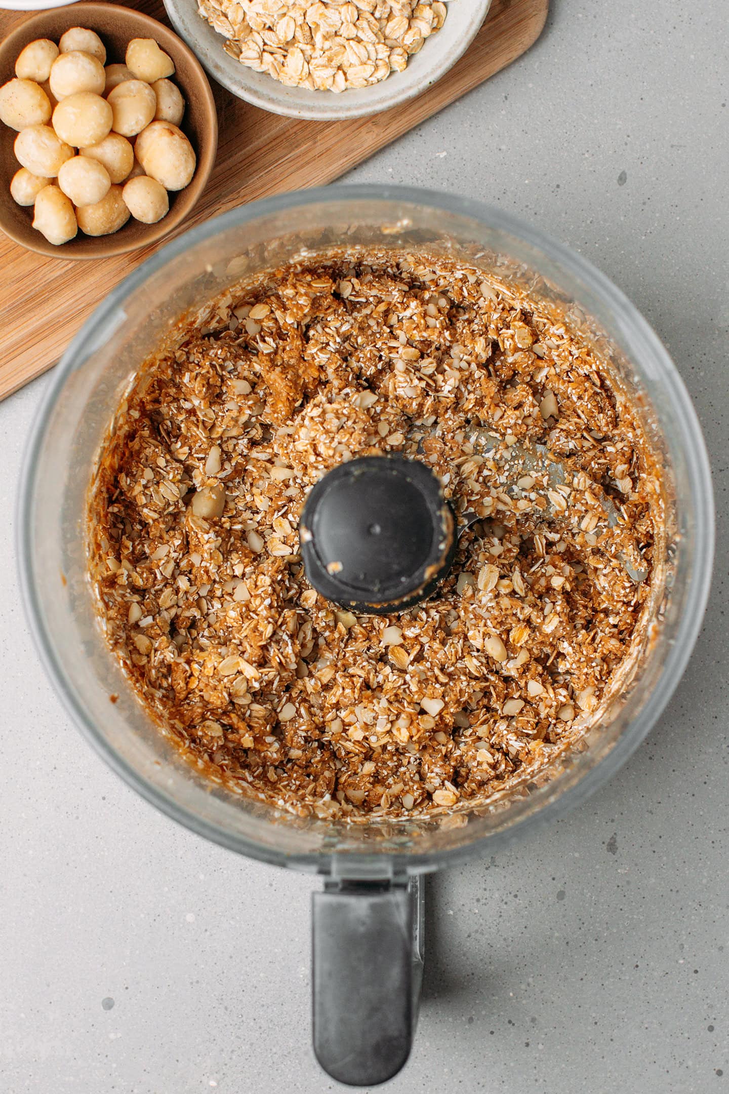 Processed rolled oats and macadamia nuts in a food processor.