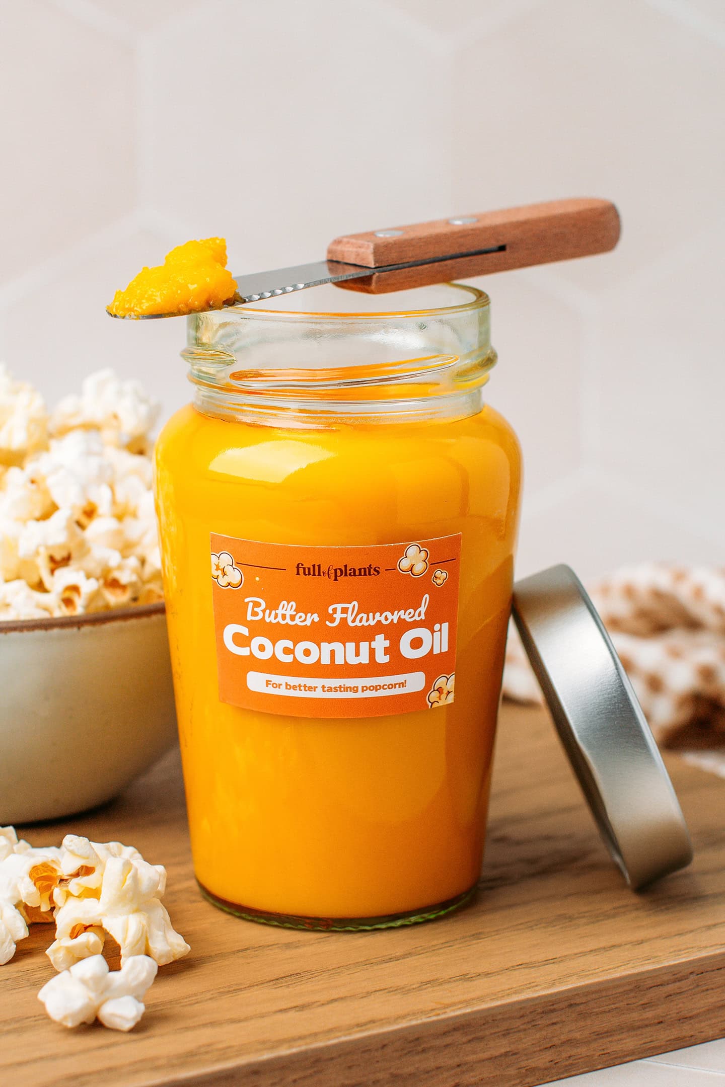 Butter flavored coconut oil in a glass jar on a wooden board.