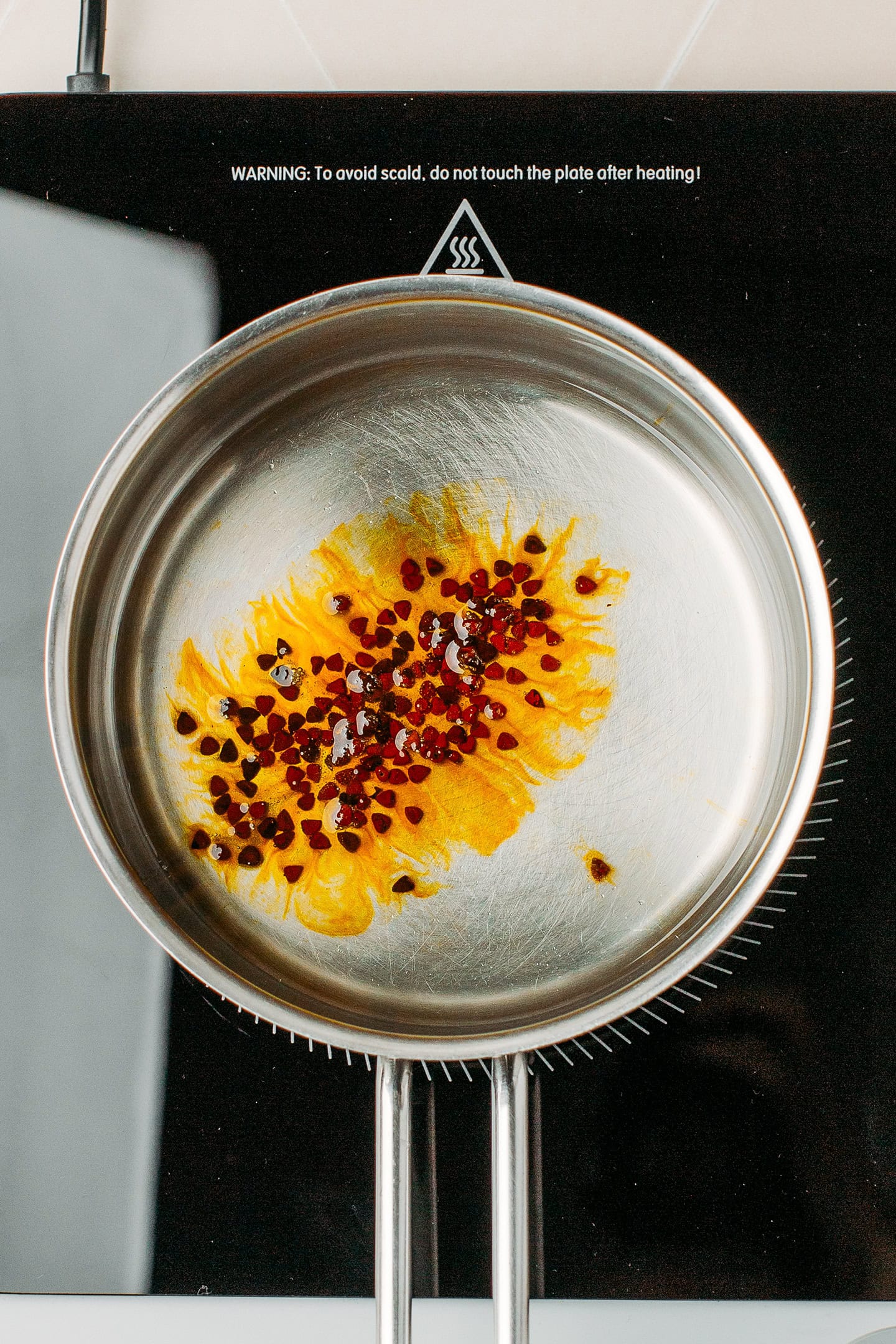 Annatto seeds and oil in a saucepan.