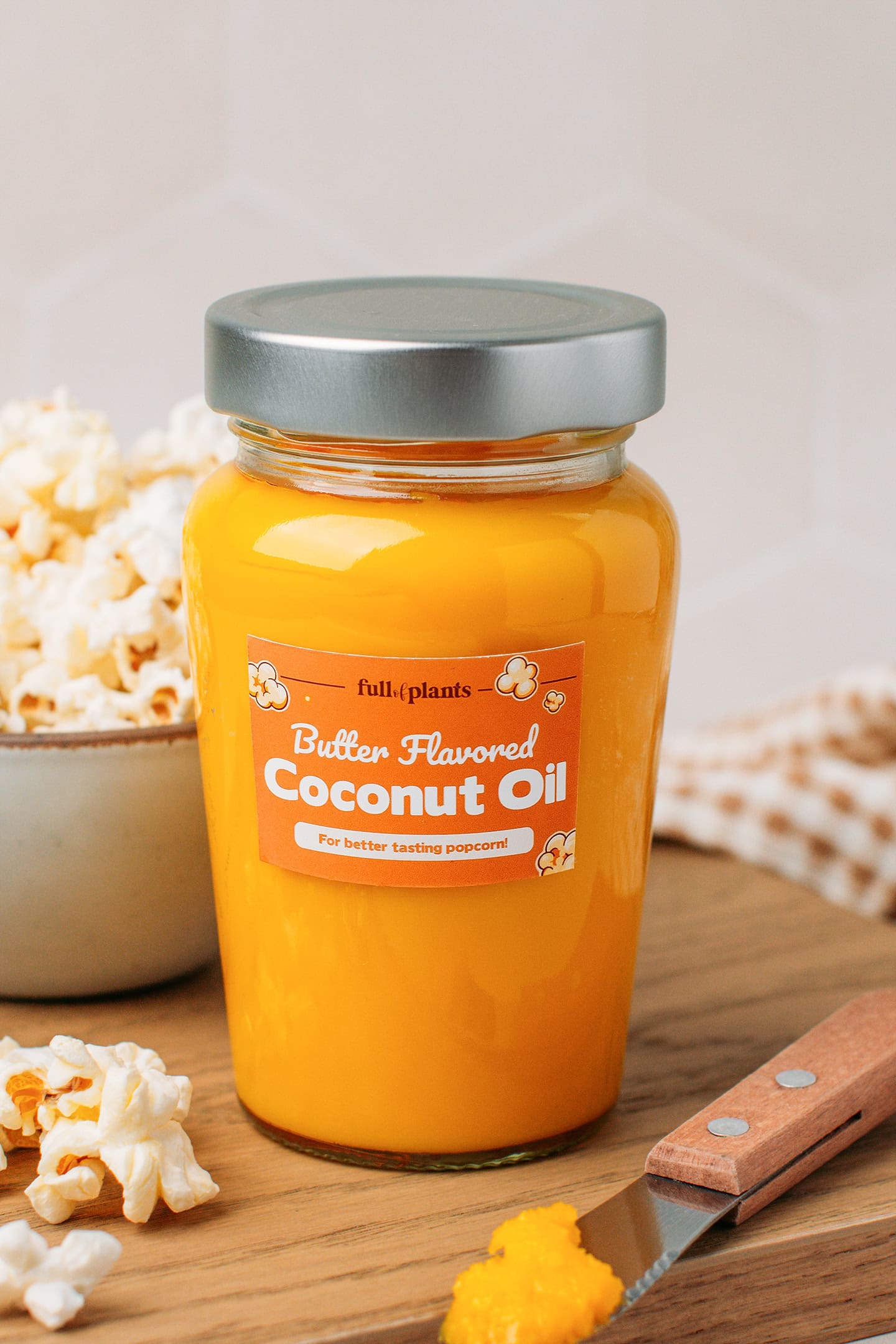 Jar filled with butter flavored coconut oil arranged on a wooden board.