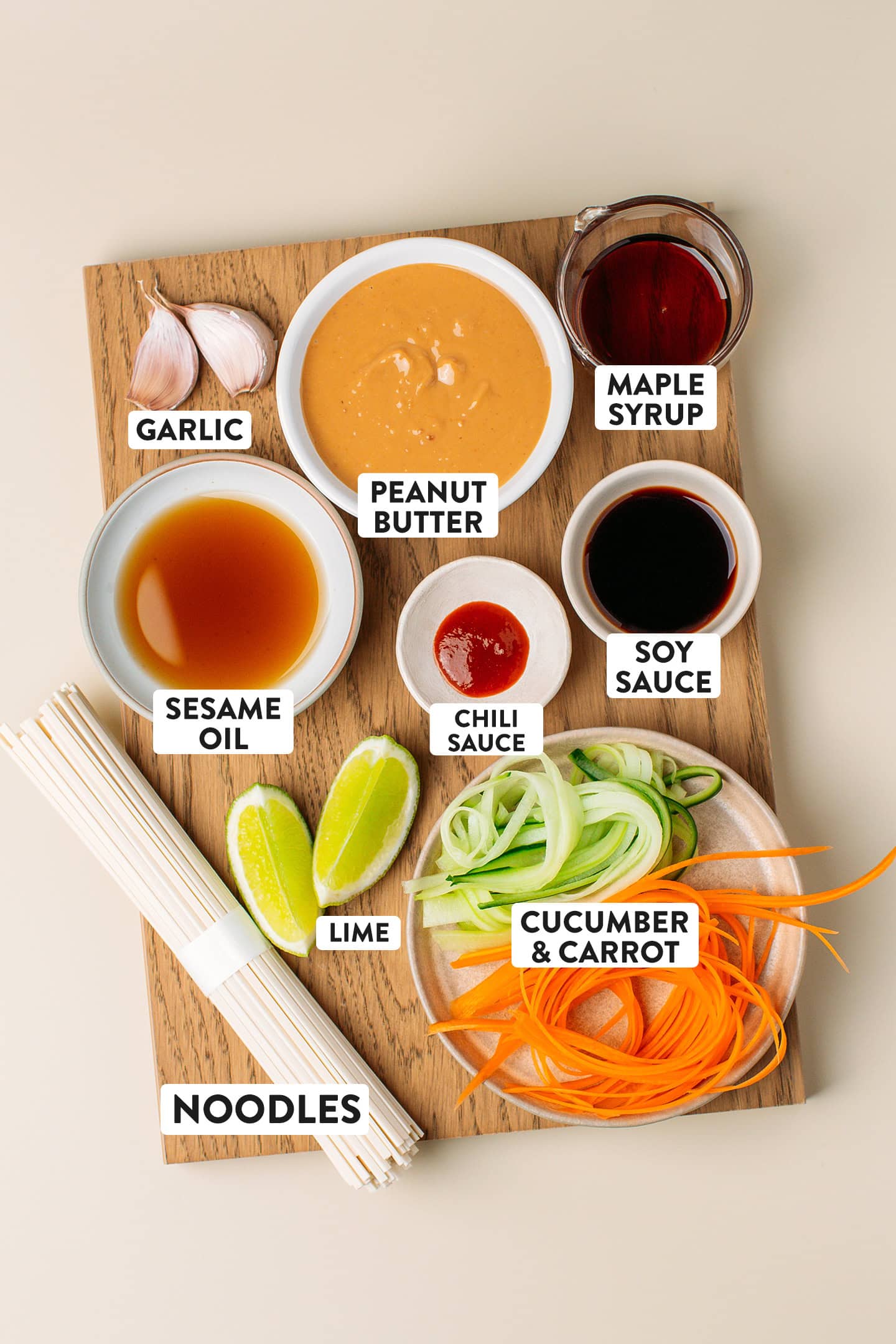 Ingredients like cucumber, carrots, sesame oil, peanut butter, and noodles.