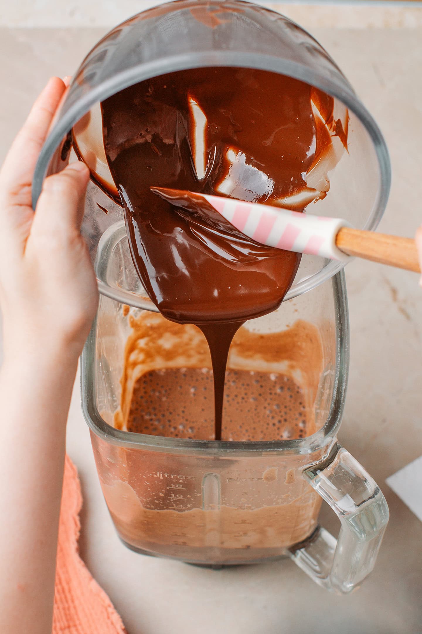 Pouring melted chocolate into a blender.