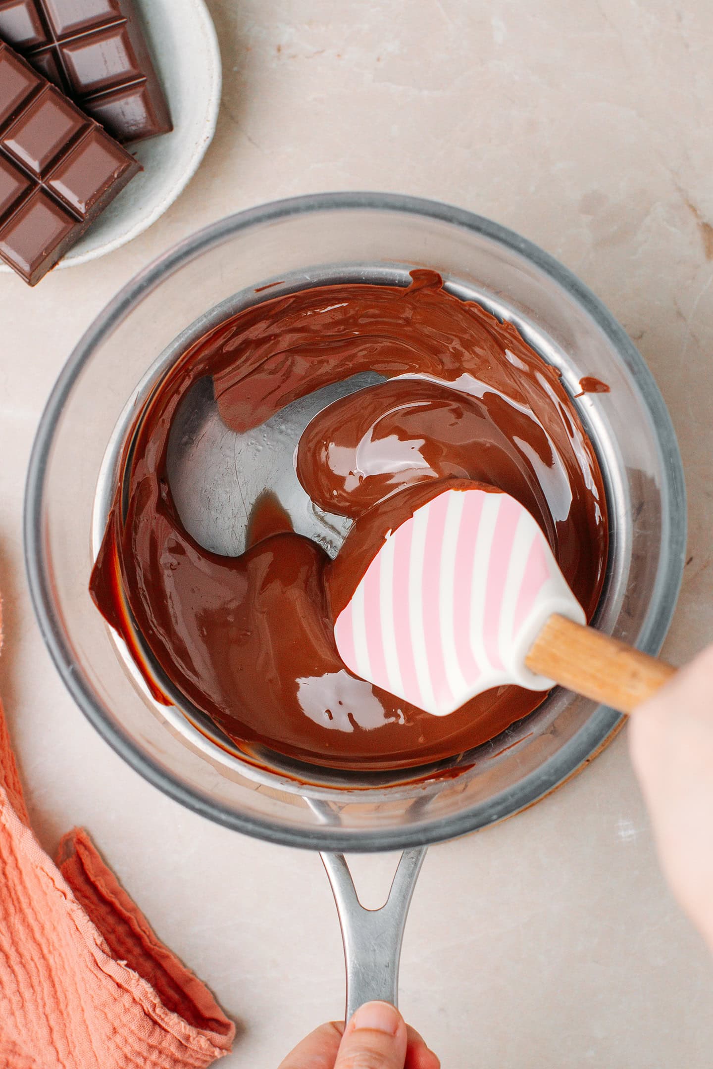 Melted dark chocolate in a glass bowl.